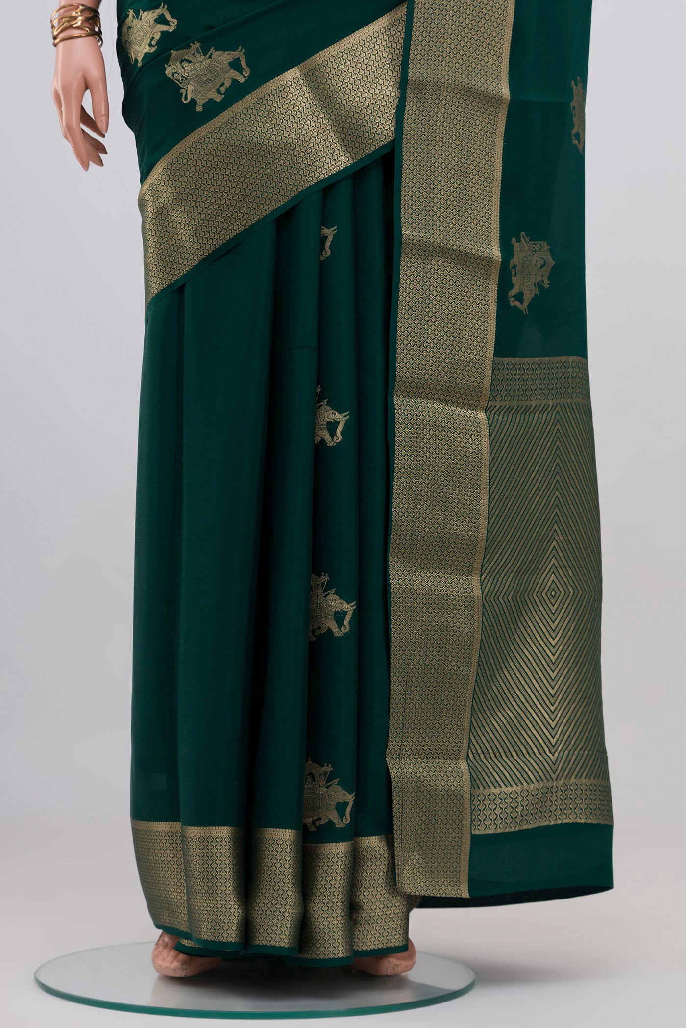 Pleats and pallu of Bottle Green Mysore Crepe Saree with Zari Butta on the body and Zari Border. 