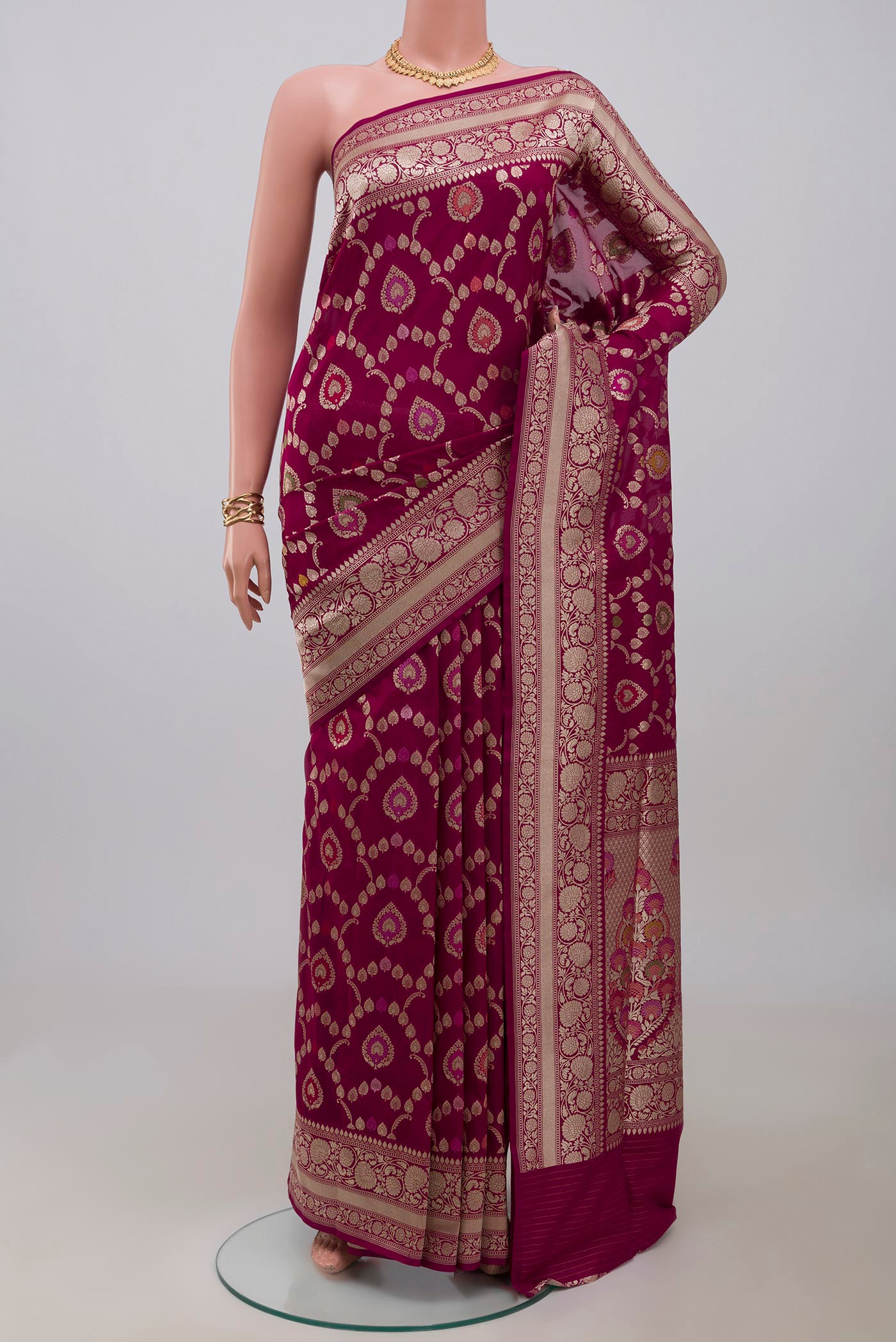 Burgundy Banarasi Silk Saree with Zari And Thread Butta on the body and Zari Border.  displayed on a mannequin