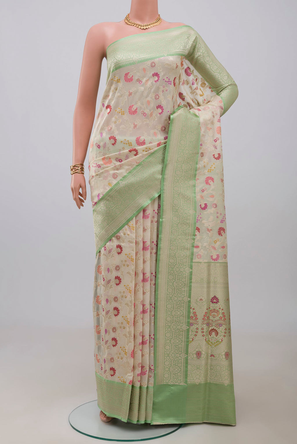 Cream Banarasi Silk Saree with Zari And Thread Butta on the body and Zari Border.  displayed on a mannequin