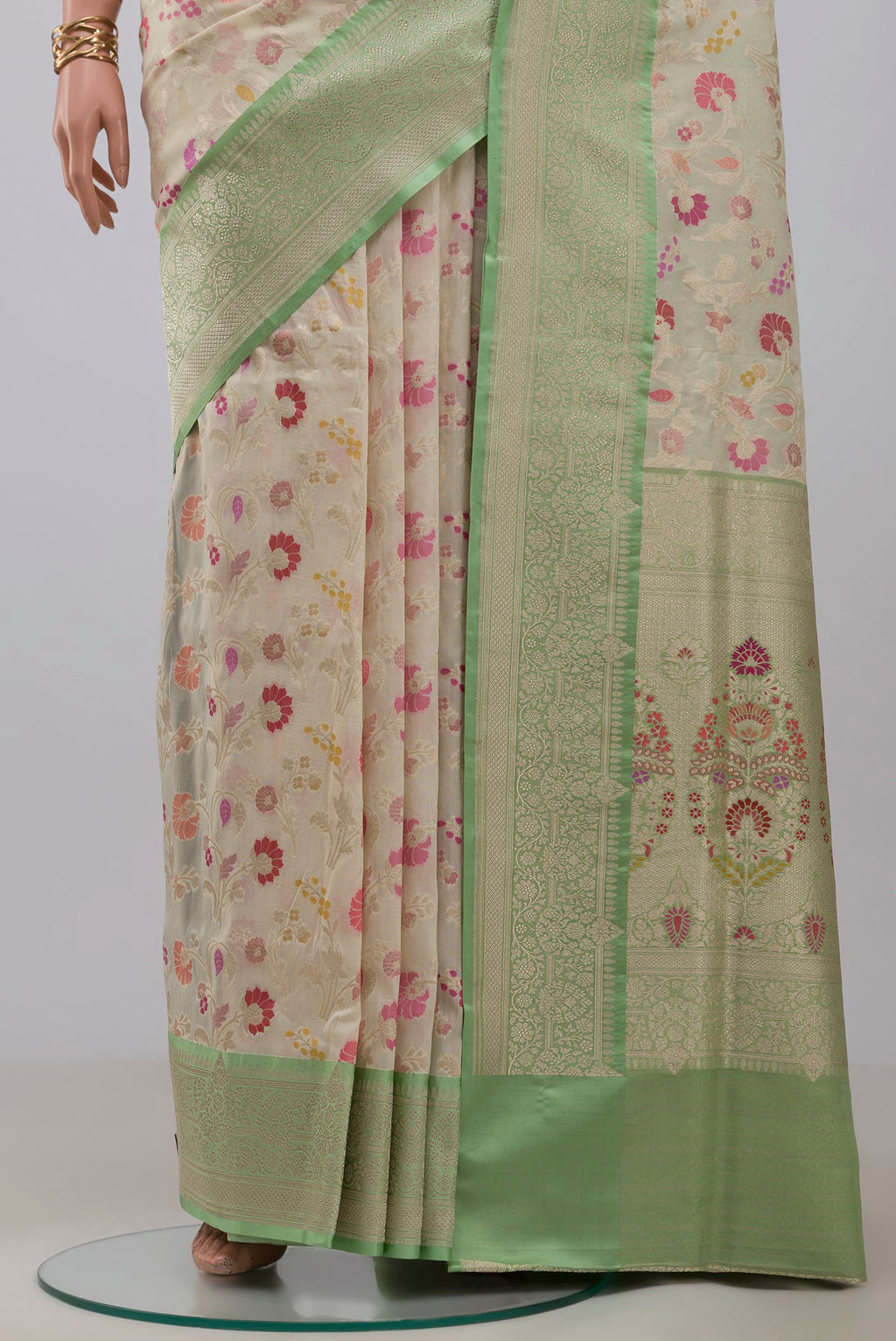 Pleats and pallu of Cream Banarasi Silk Saree with Zari And Thread Butta on the body and Zari Border. 