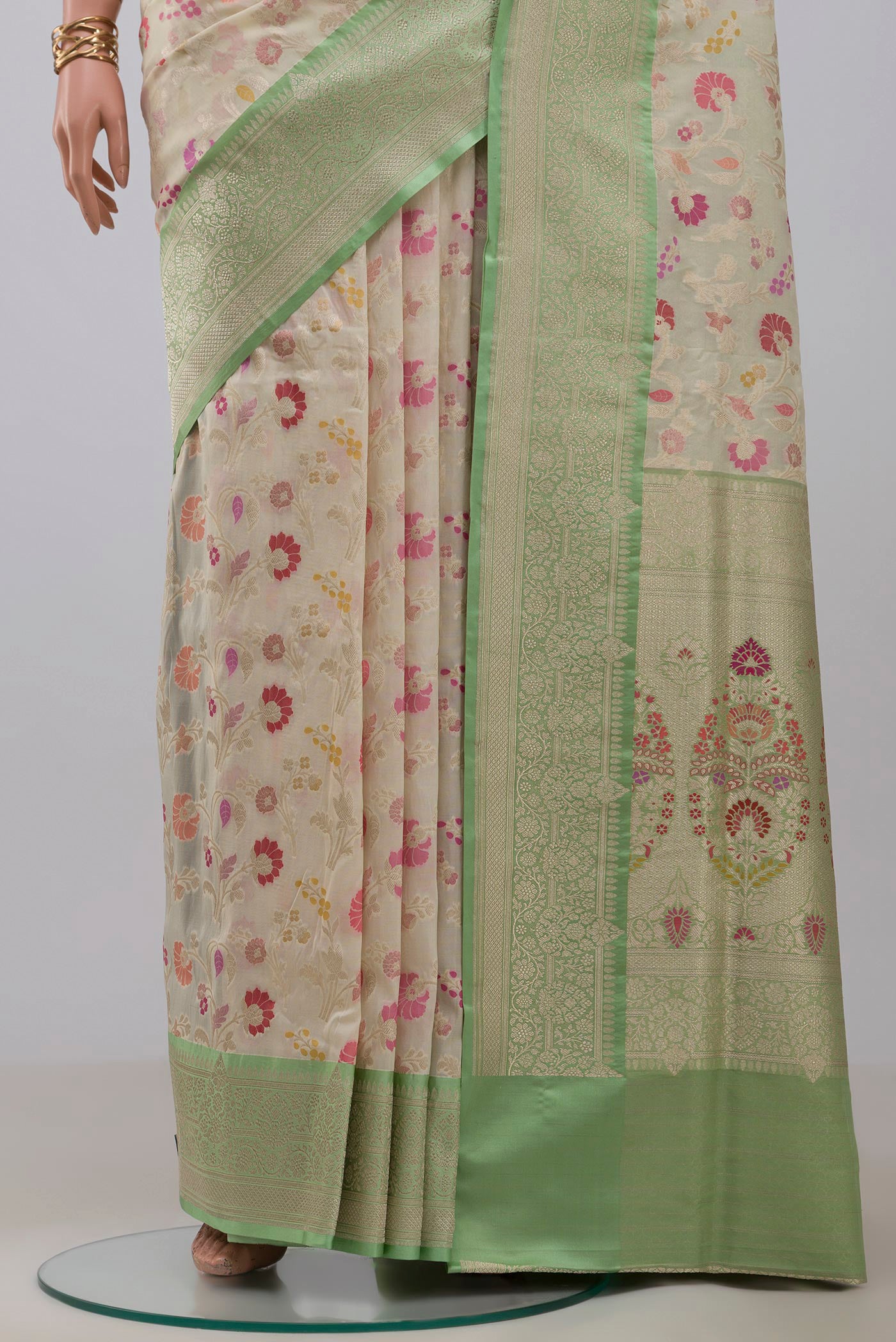 Pleats and pallu of Cream Banarasi Silk Saree with Zari And Thread Butta on the body and Zari Border. 