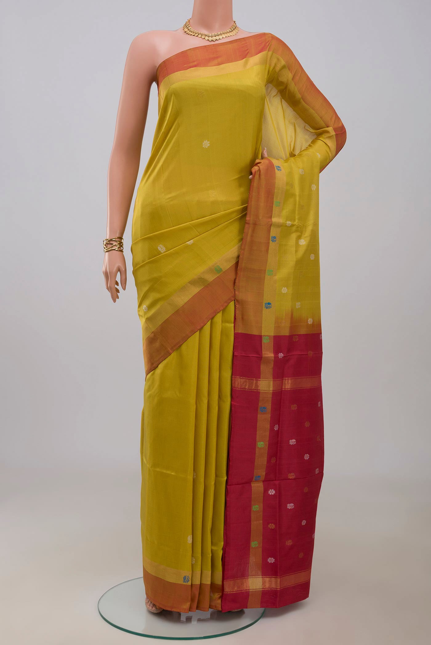 Yellow Uppada Silk Saree with Zari And Thread Butta on the body and Fancy Border.  displayed on a mannequin