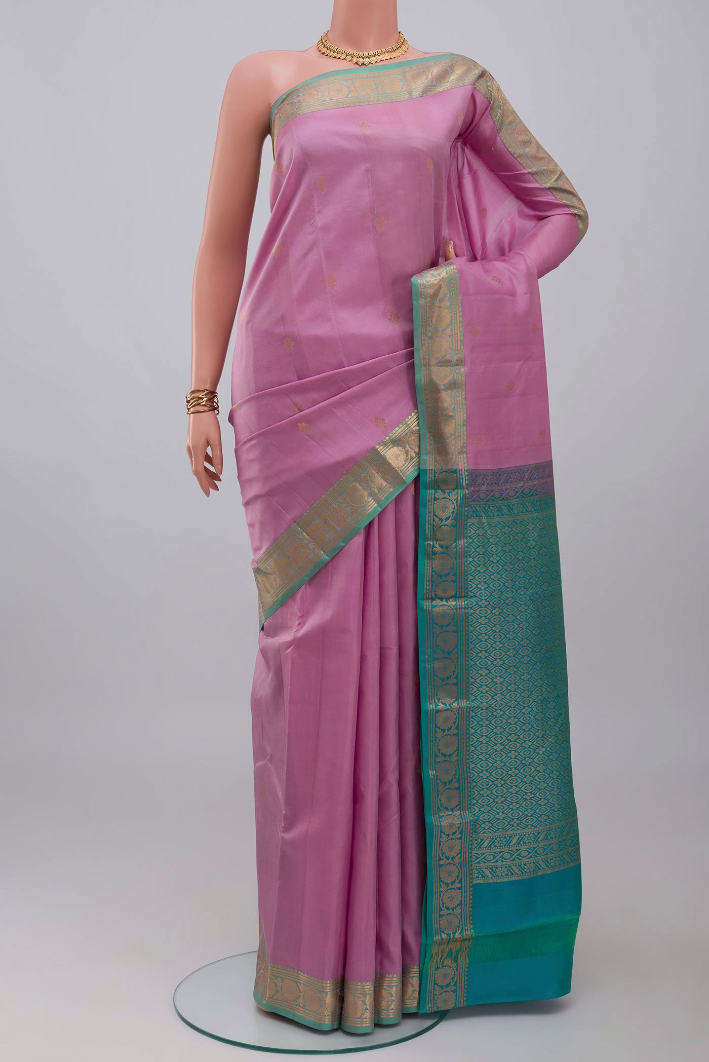 Lavender Kanchipuram Silk Saree with Zari Butta on the body and Zari Border.  displayed on a mannequin