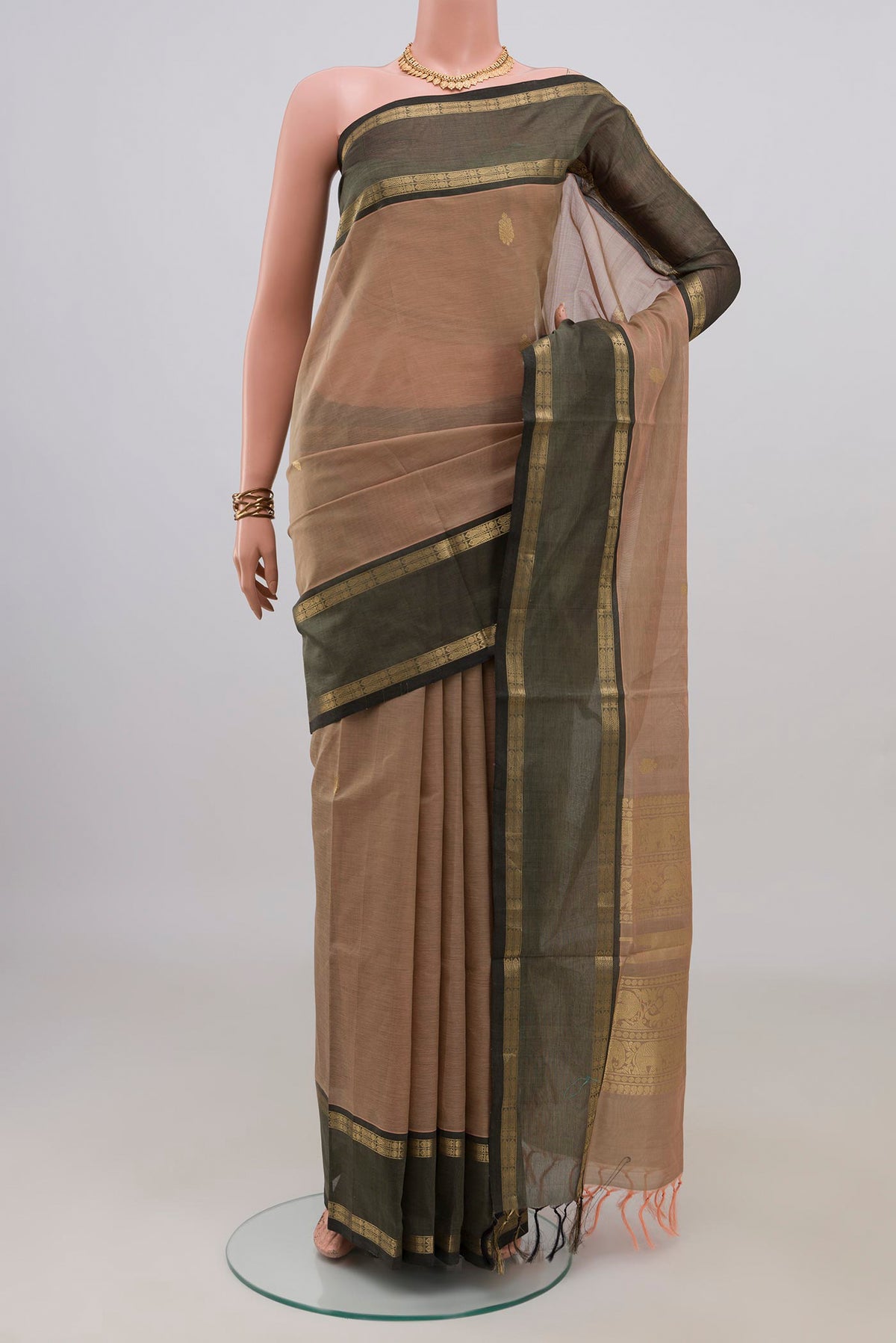 Beige Silk Cotton Saree with Zari Butta on the body and Zari Border.  displayed on a mannequin