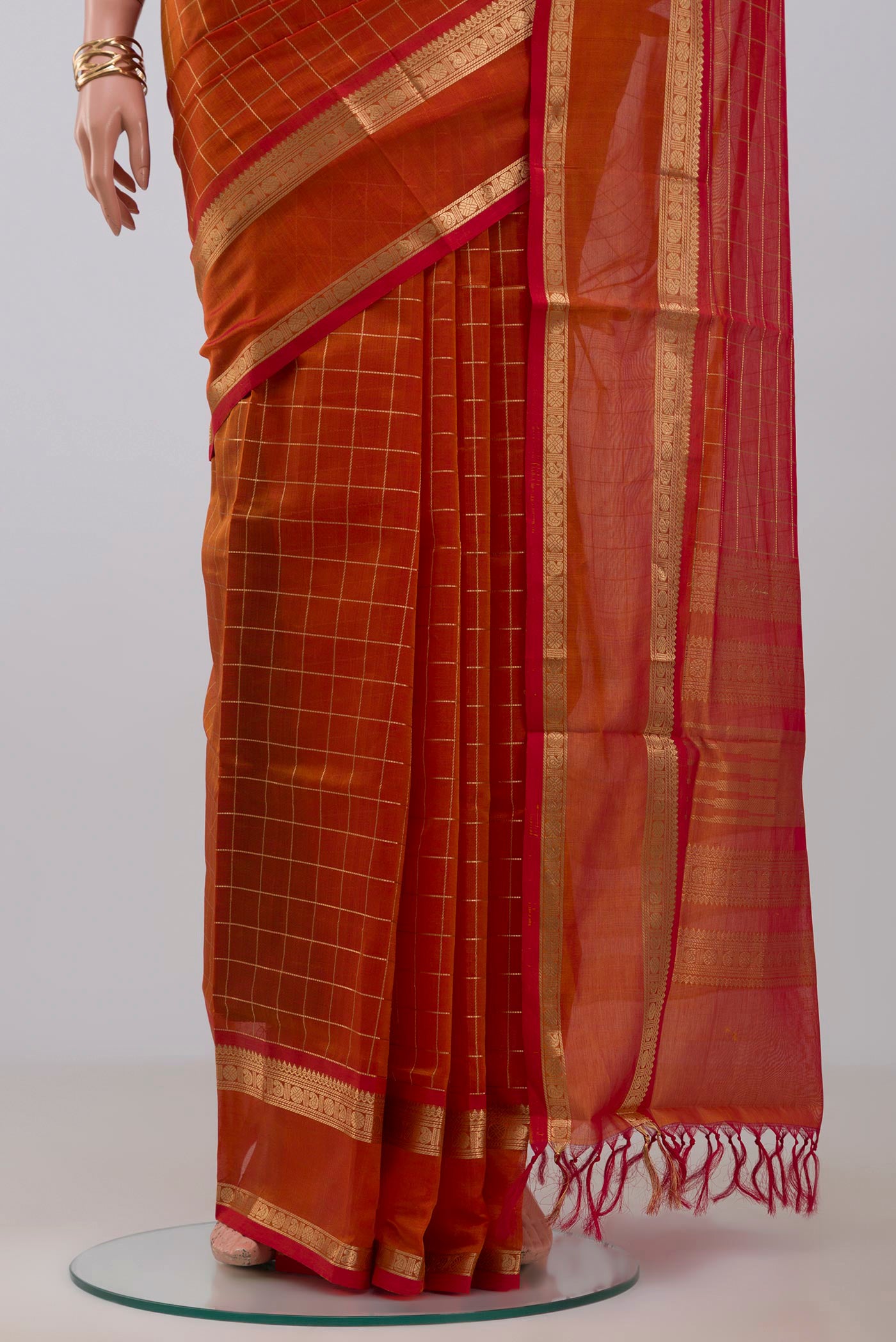 Pleats and pallu of Orange Silk Cotton Saree with Checked design on the body and Zari Border. 