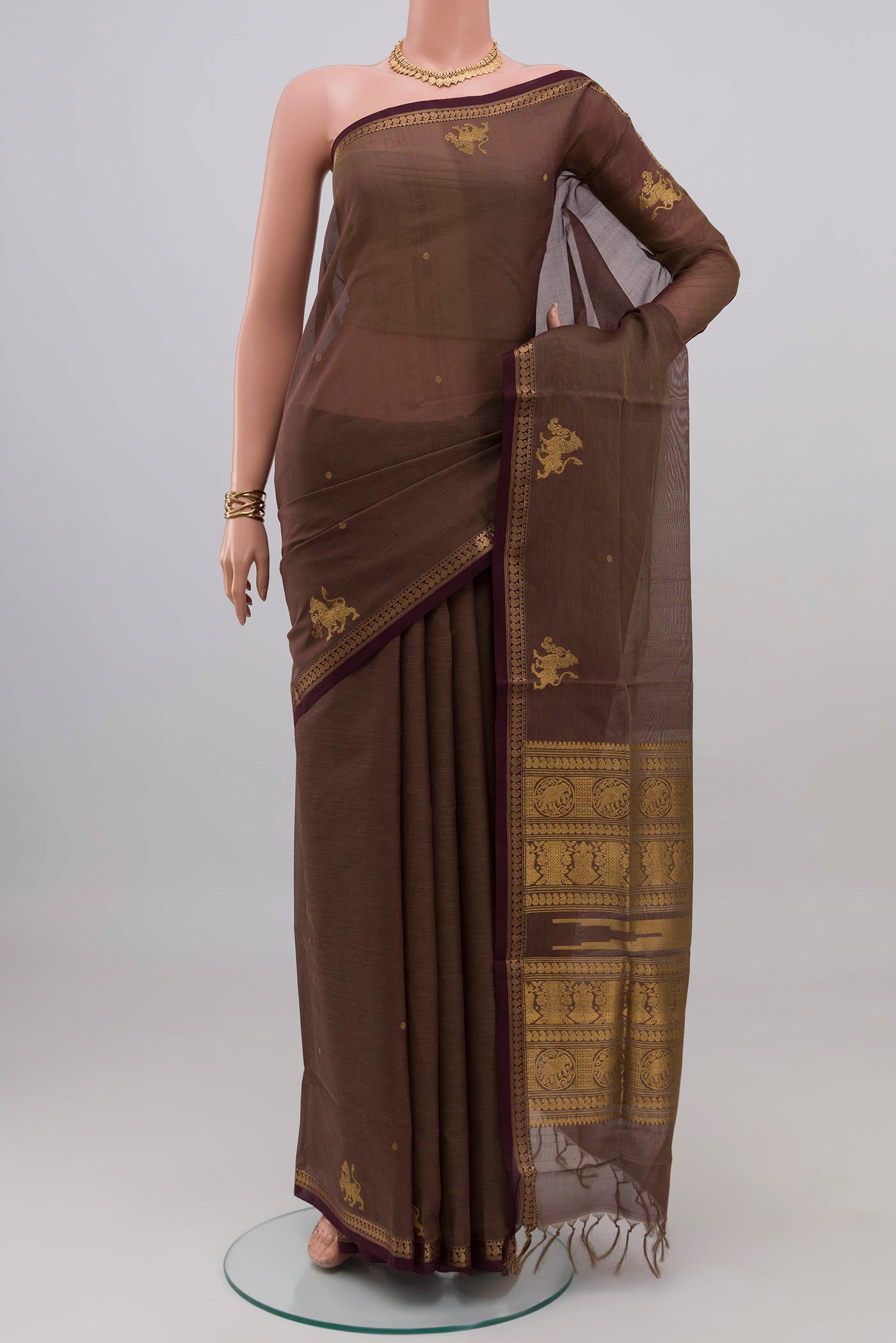 Brown Silk Cotton Saree with Zari Butta on the body and Thin Zari Line.  displayed on a mannequin