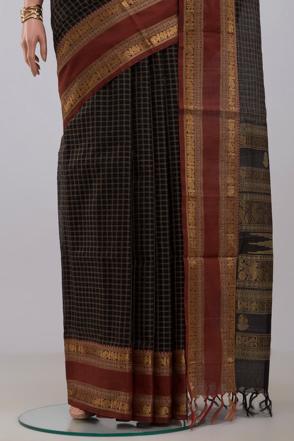 Pleats and pallu of Black Silk Cotton Saree with Checked design on the body and Zari Border. 