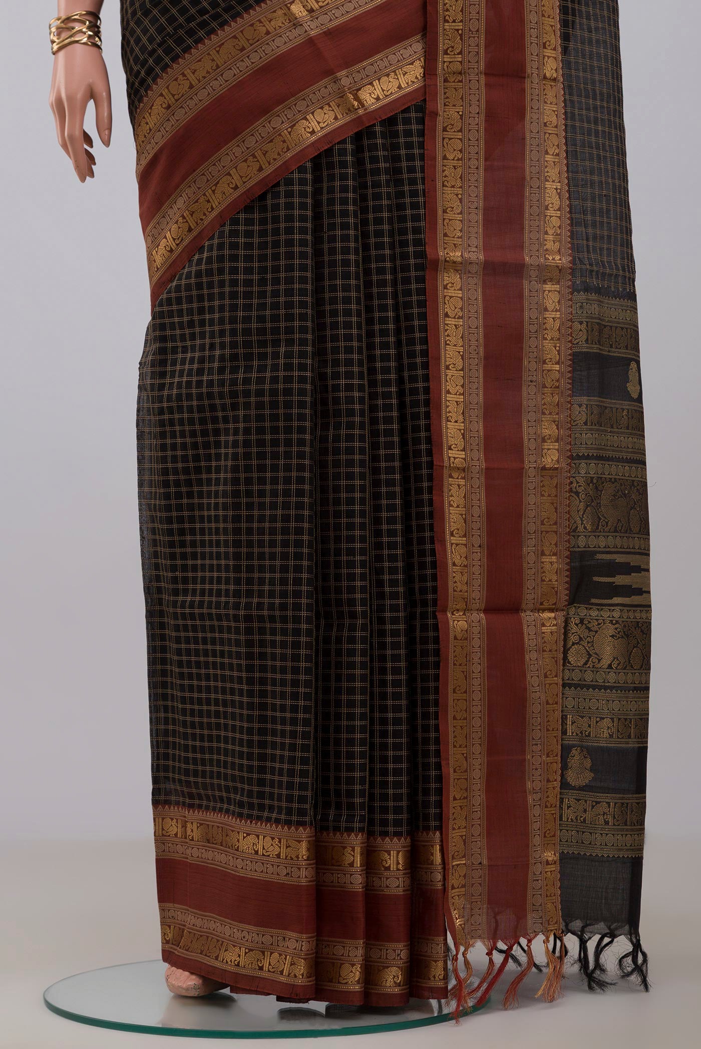 Pleats and pallu of Black Silk Cotton Saree with Checked design on the body and Zari Border. 