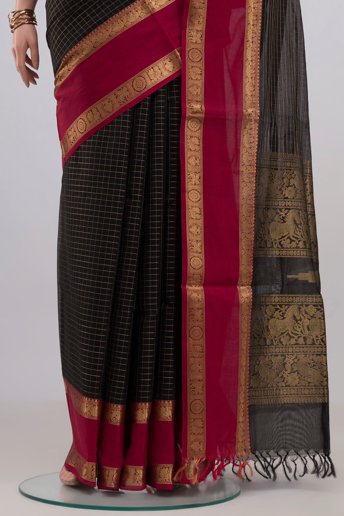 Pleats and pallu of Black Silk Cotton Saree with Checked design on the body and Zari Border. 