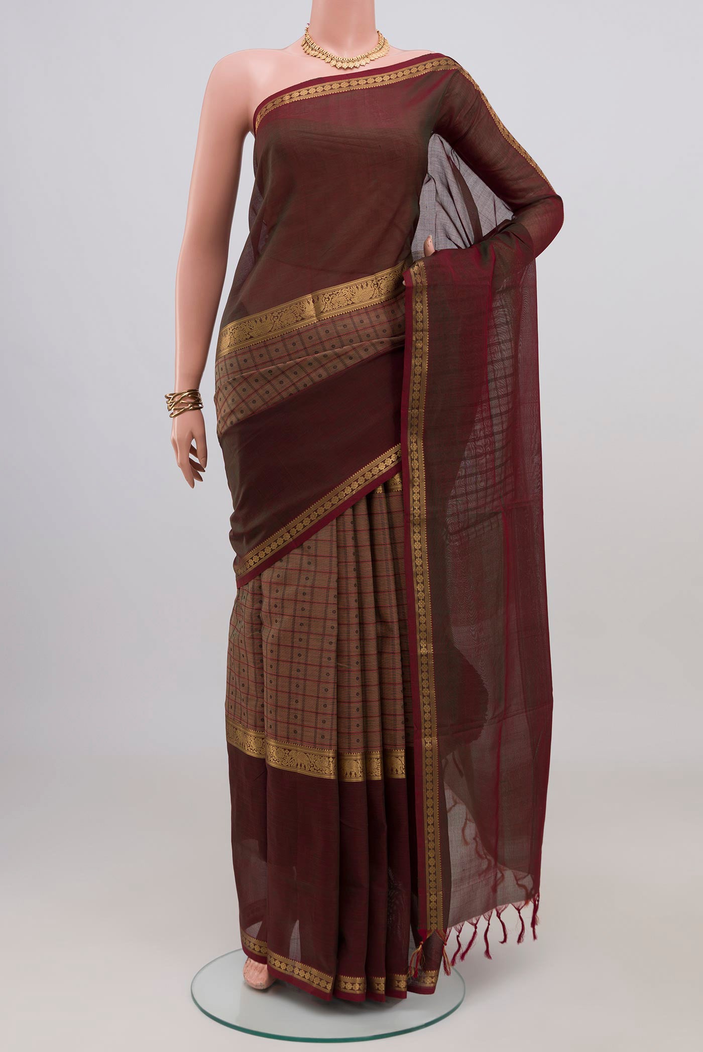 Brown Silk Cotton Saree with Checked design on the body and Zari Border.  displayed on a mannequin