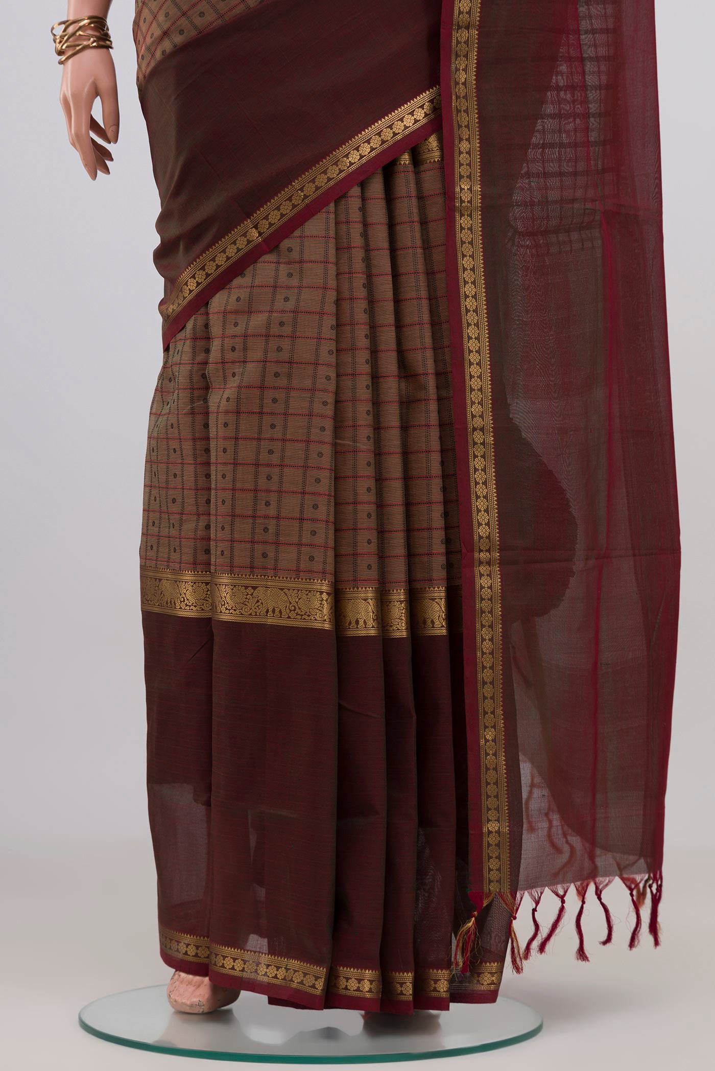 Pleats and pallu of Brown Silk Cotton Saree with Checked design on the body and Zari Border. 