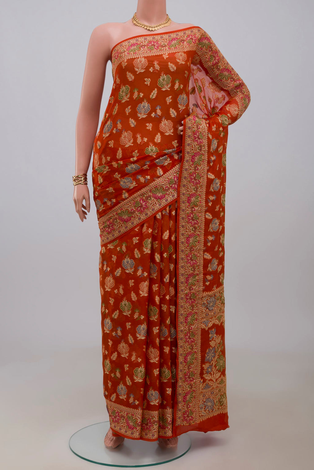 Orange Banarasi Georgette Saree with Zari And Thread Butta on the body and Zari And Thread Border.  displayed on a mannequin