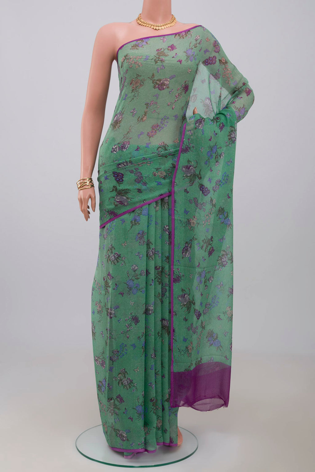 Green Chiffon Saree with Printed design on the body and Without Border.  displayed on a mannequin