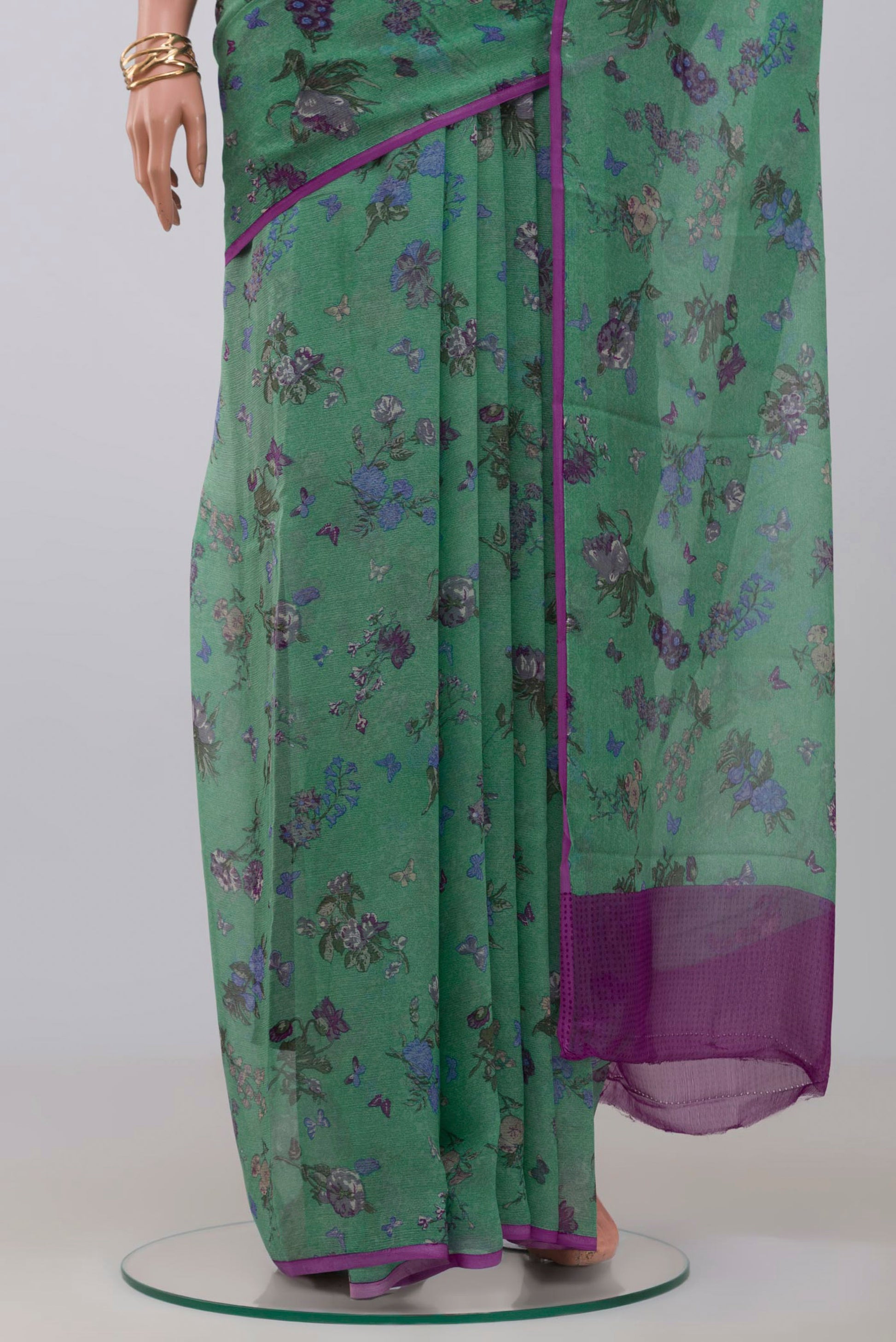 Pleats and pallu of Green Chiffon Saree with Printed design on the body and Without Border. 