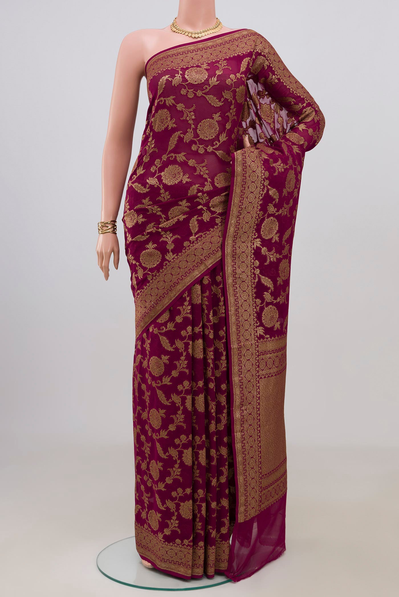 Magenta Banarasi Georgette Saree with Zari Brocade on the body and Zari Border.  displayed on a mannequin