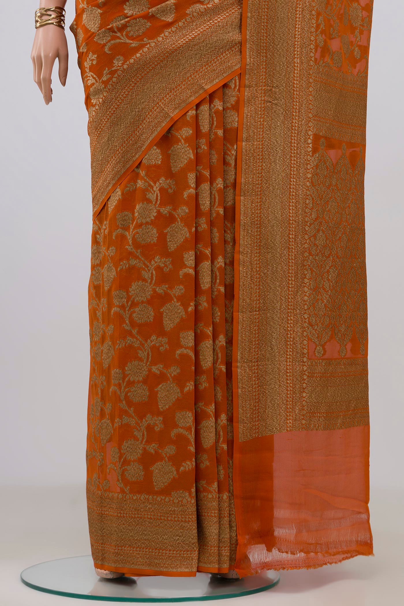 Pleats and pallu of Brick Orange Banarasi Georgette Saree with Zari Brocade on the body and Zari Border. 