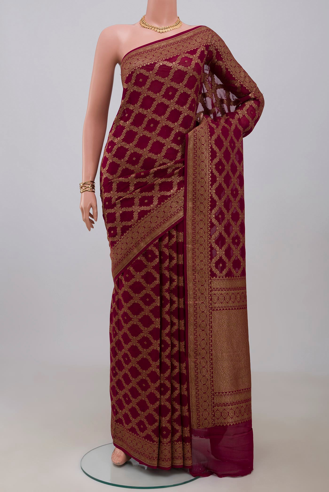 Maroon Georgette Saree with Fancy on the body and Fancy Border.  displayed on a mannequin