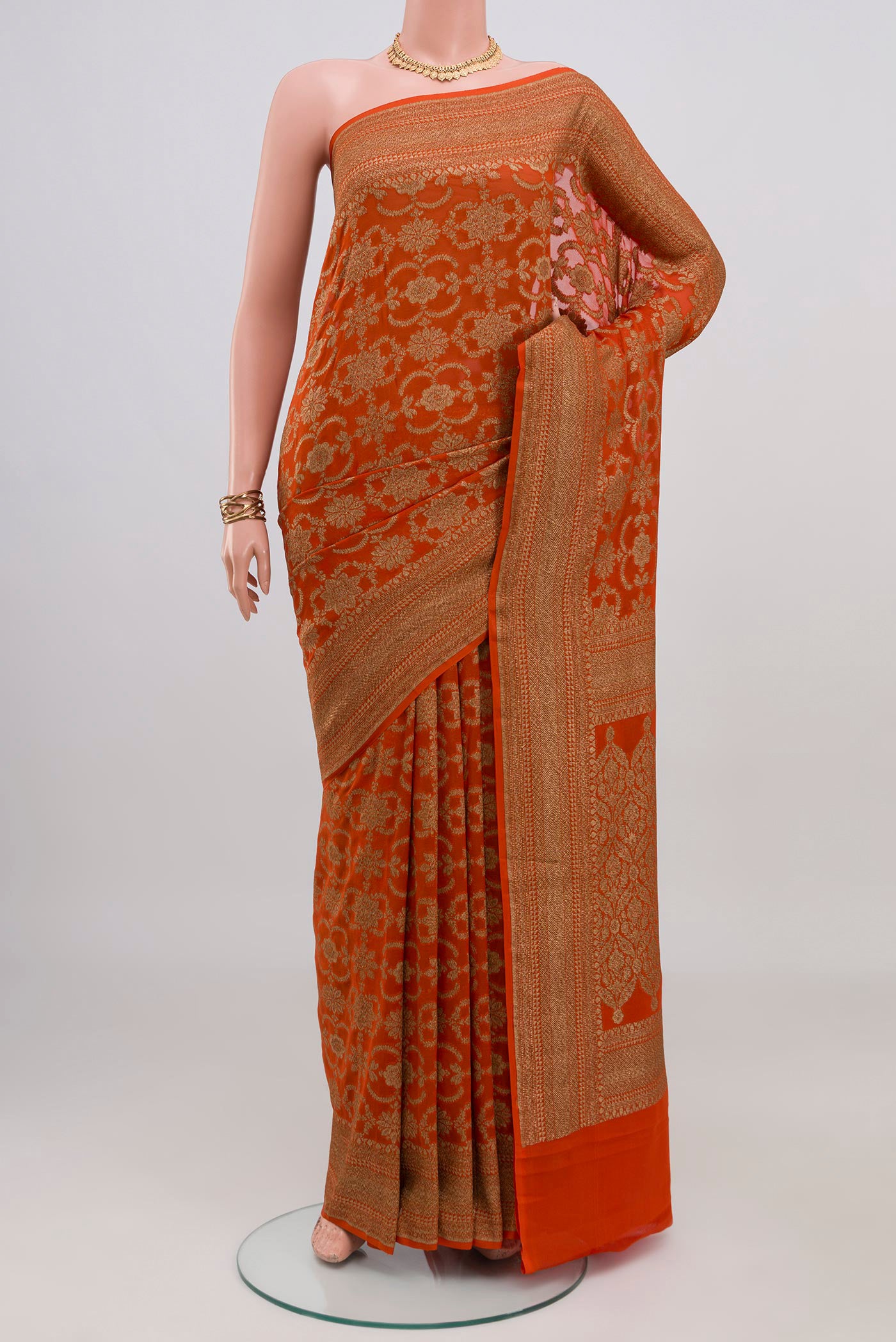 Orange Banarasi Georgette Saree with Zari Brocade on the body and Zari Border.  displayed on a mannequin