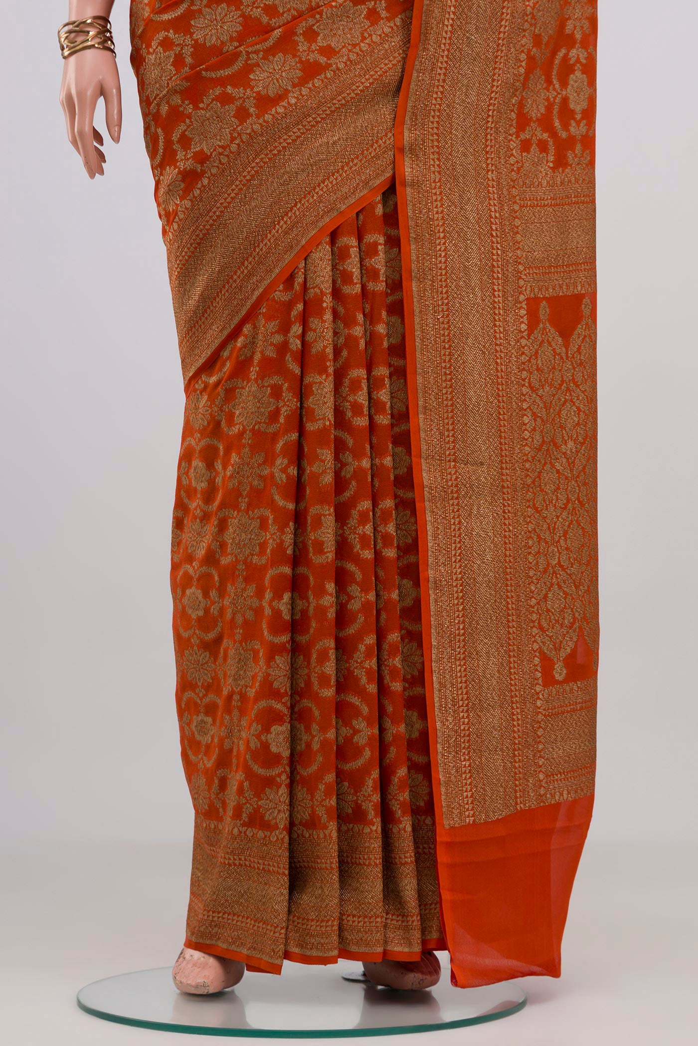 Pleats and pallu of Orange Banarasi Georgette Saree with Zari Brocade on the body and Zari Border. 