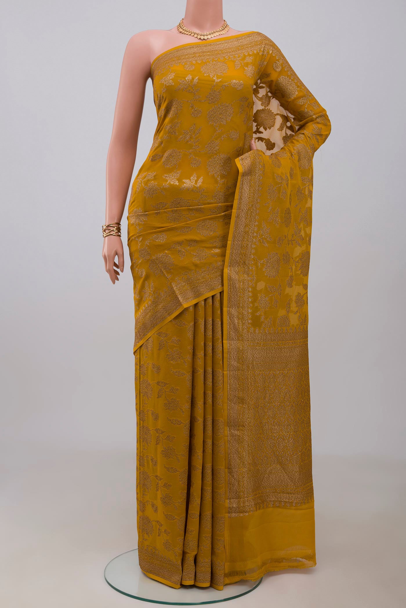 Mustard Banarasi Georgette Saree with Zari Brocade on the body and Zari Border.  displayed on a mannequin
