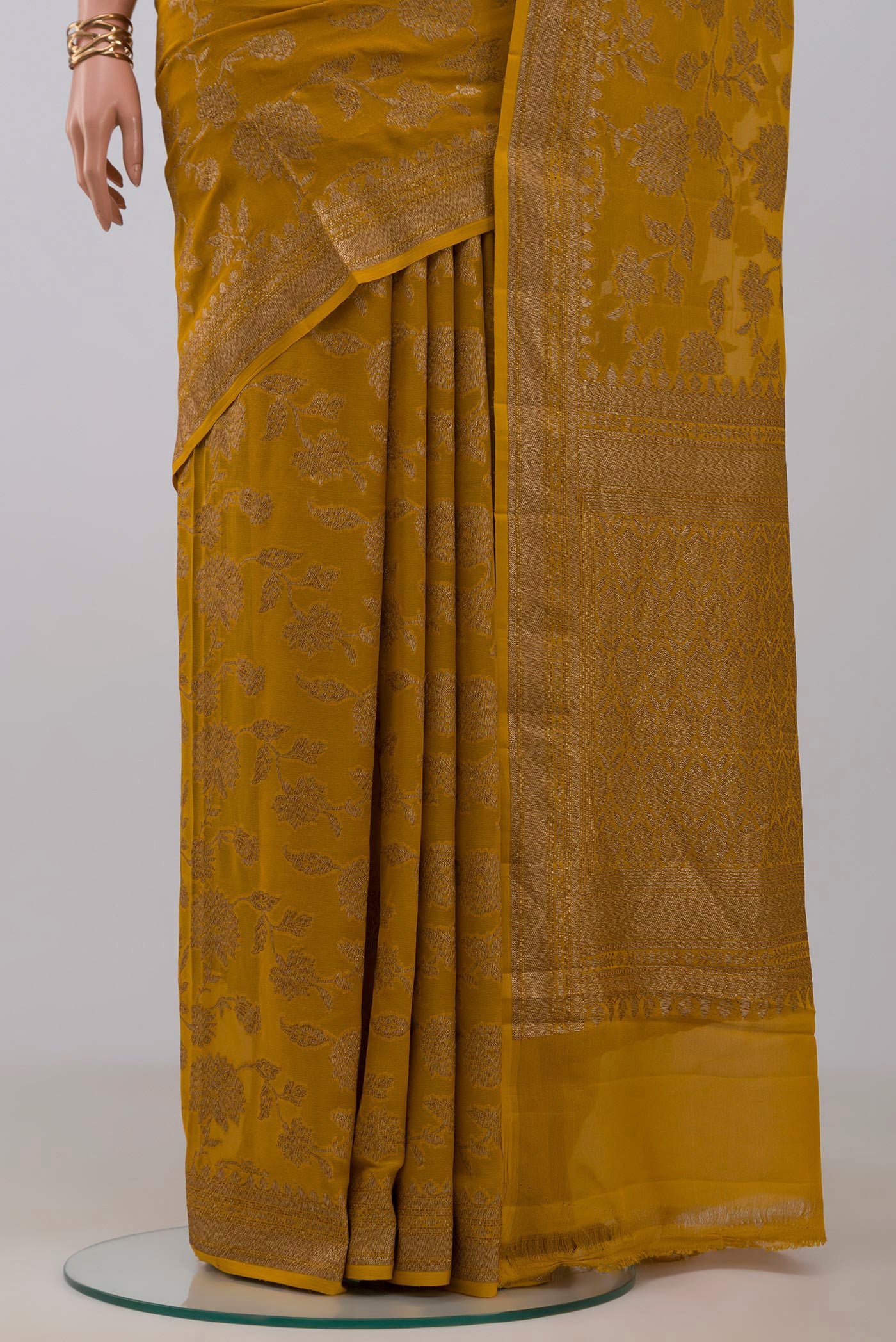 Pleats and pallu of Mustard Banarasi Georgette Saree with Zari Brocade on the body and Zari Border. 