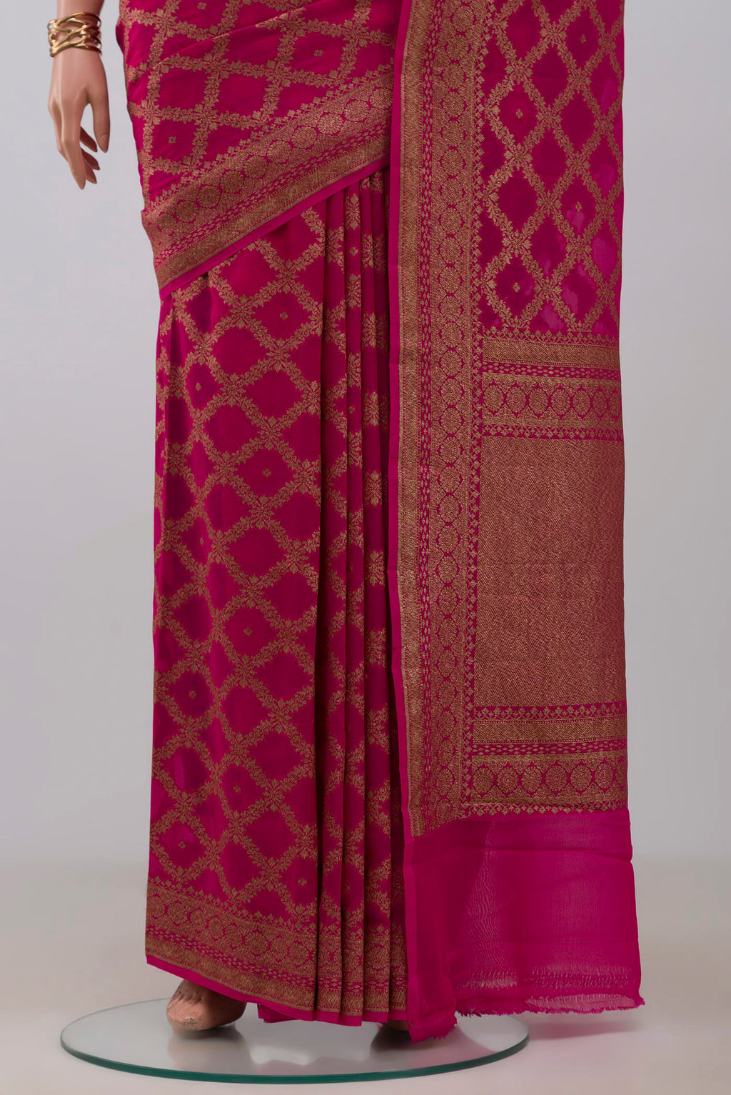 Pleats and pallu of Rani Pink Banarasi Georgette Saree with Zari Butta on the body and Fancy Border. 
