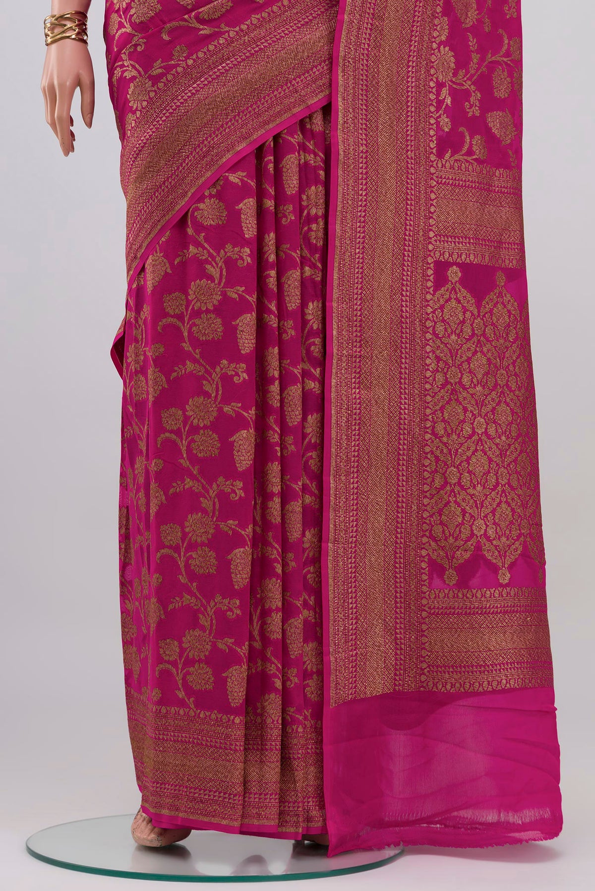 Pleats and pallu of Rani Pink Banarasi Georgette Saree with Zari Butta on the body and Zari Border. 
