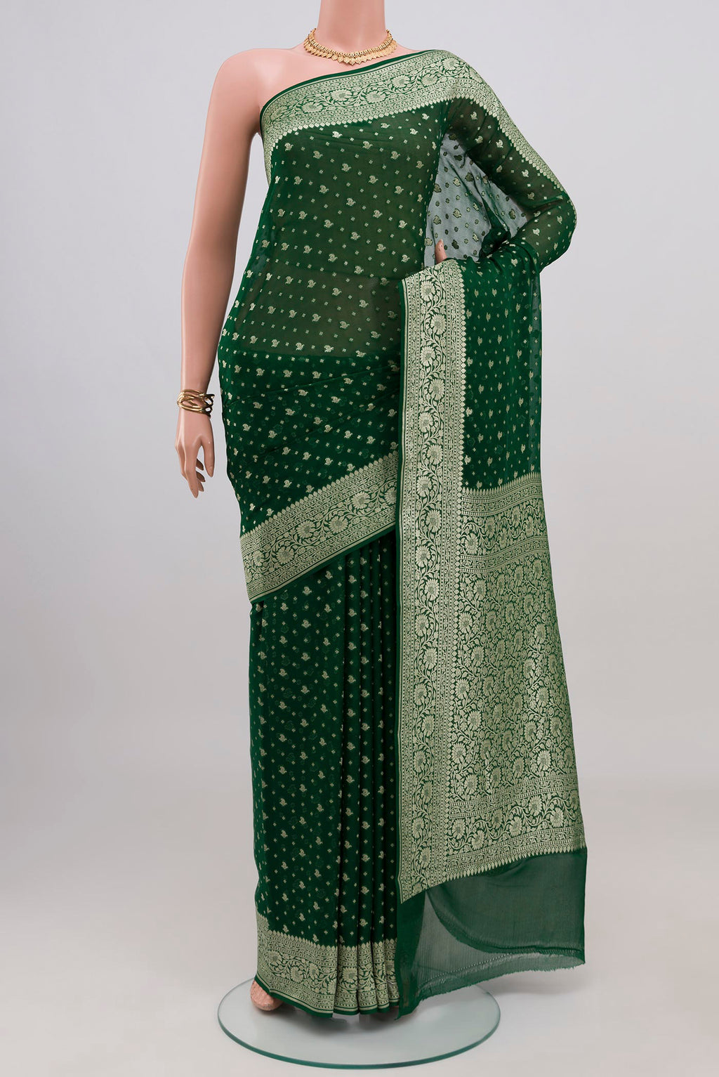 Bottle Green Banarasi Georgette Saree with Zari Butta on the body and Zari Border.  displayed on a mannequin