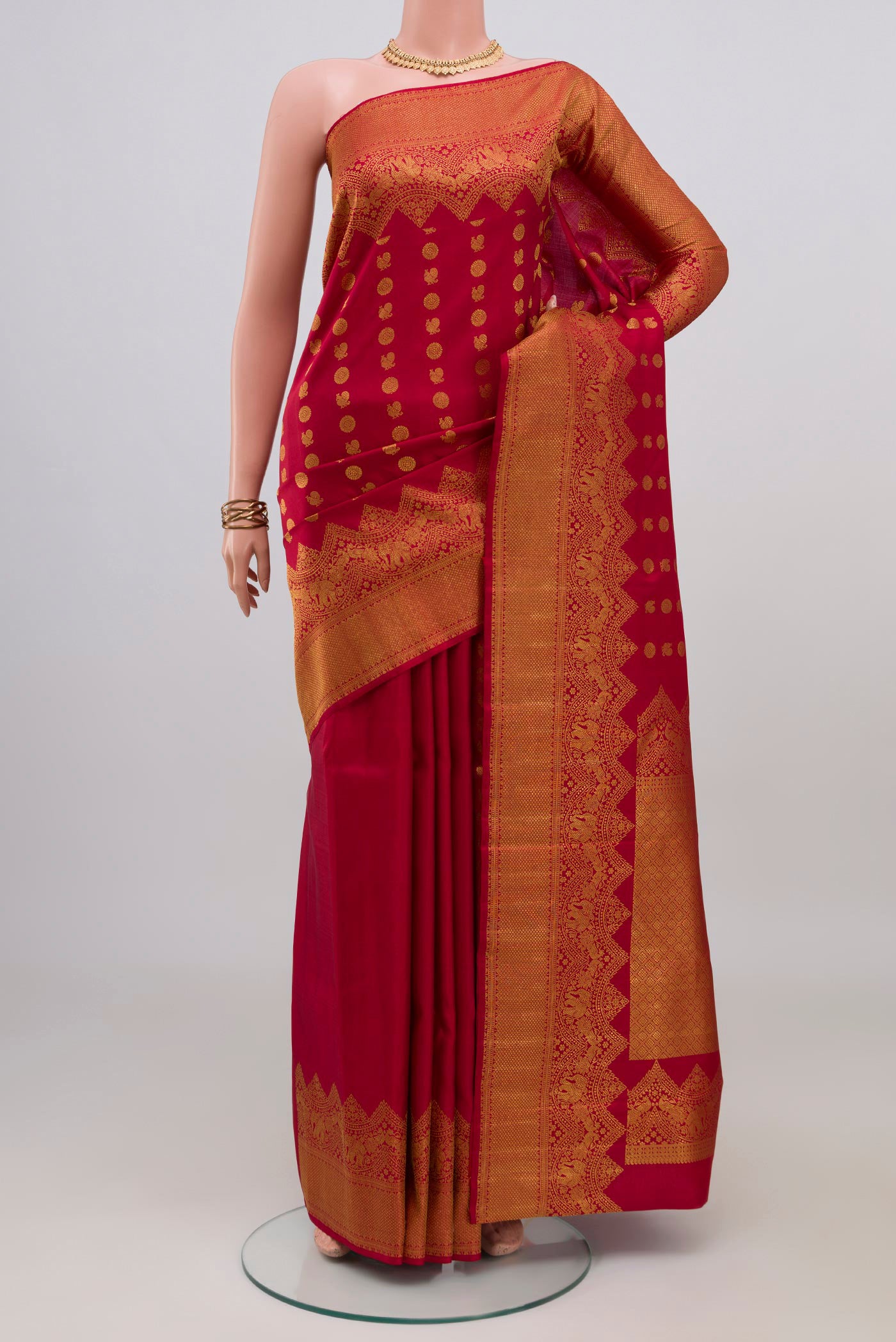 Maroon Kanjivaram Silk Saree with Zari Butta on the body and Fancy Border.  displayed on a mannequin