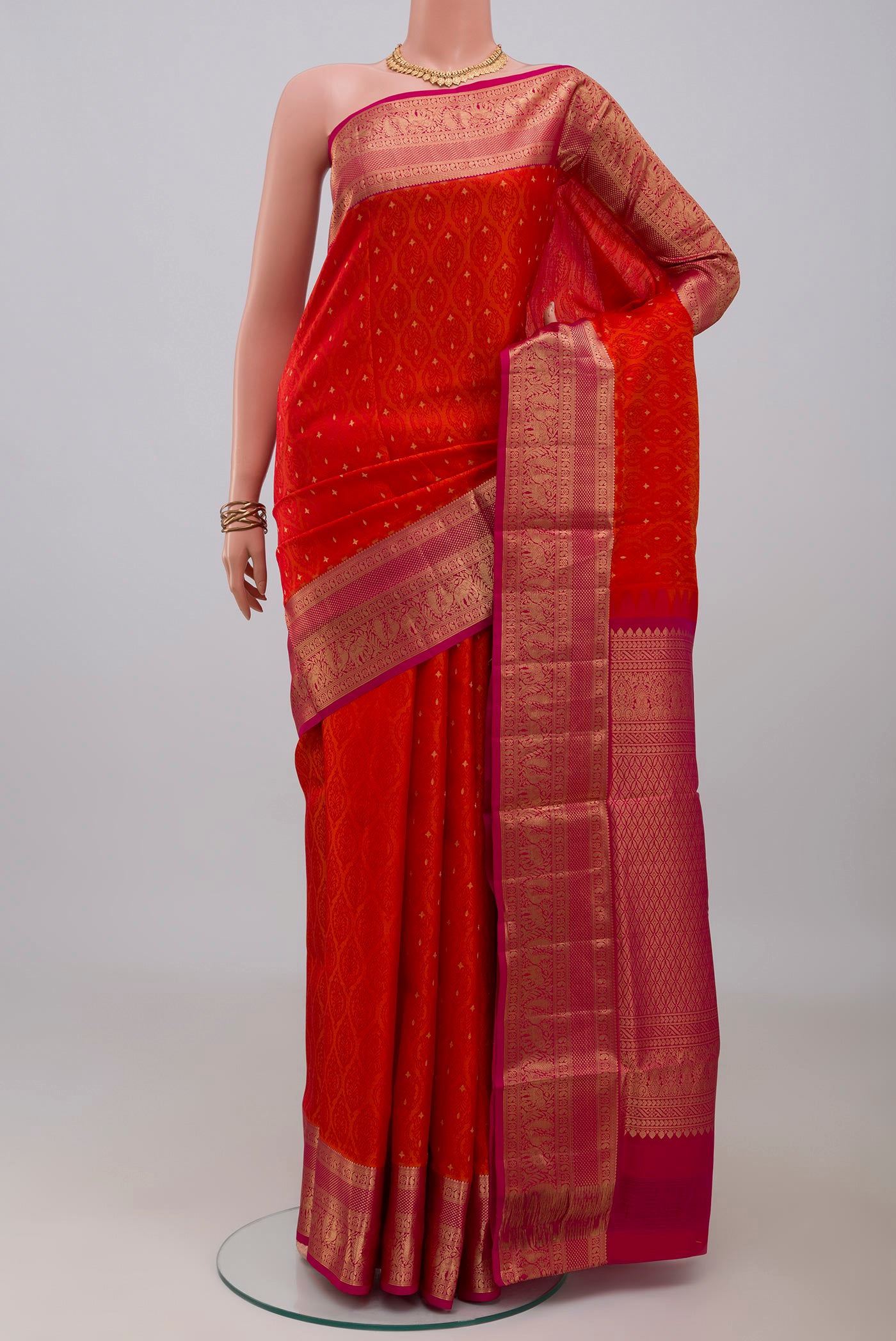 Orange Soft Silk Saree with Jacquard With Zari Butta on the body and Zari Border.  displayed on a mannequin