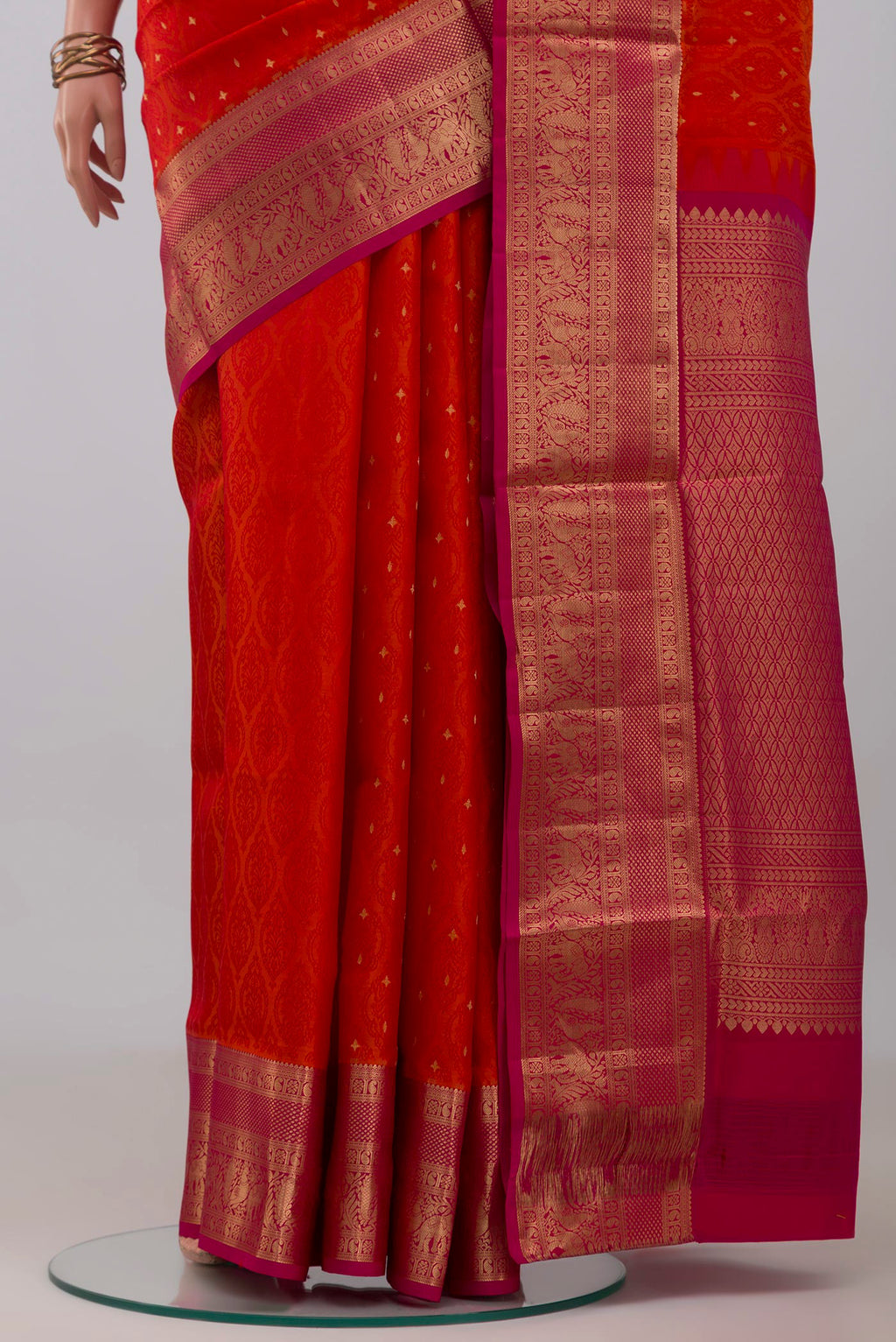 Pleats and pallu of Orange Soft Silk Saree with Jacquard With Zari Butta on the body and Zari Border. 