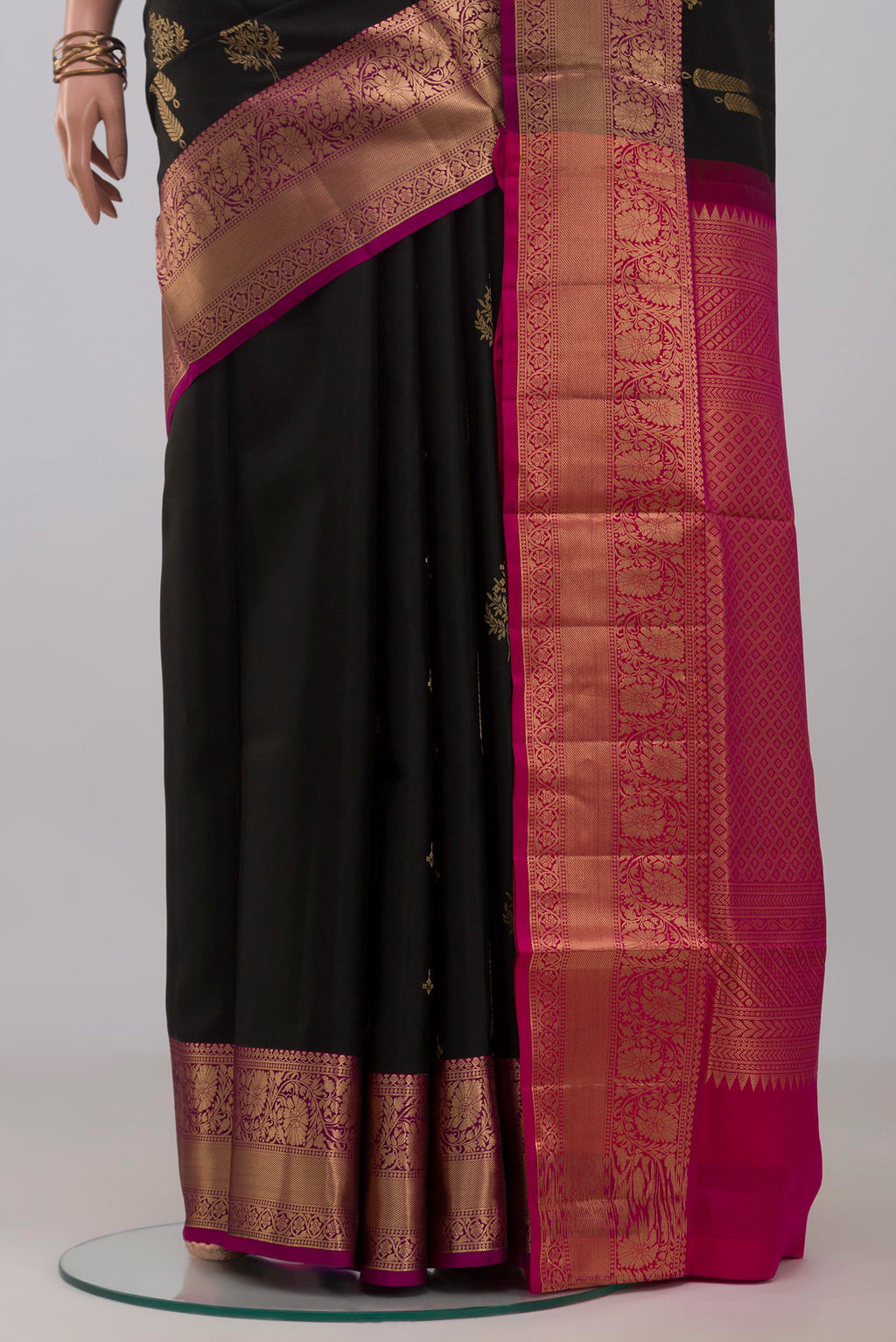 Pleats and pallu of Black Soft Silk Saree with Zari Butta on the body and Zari Border. 