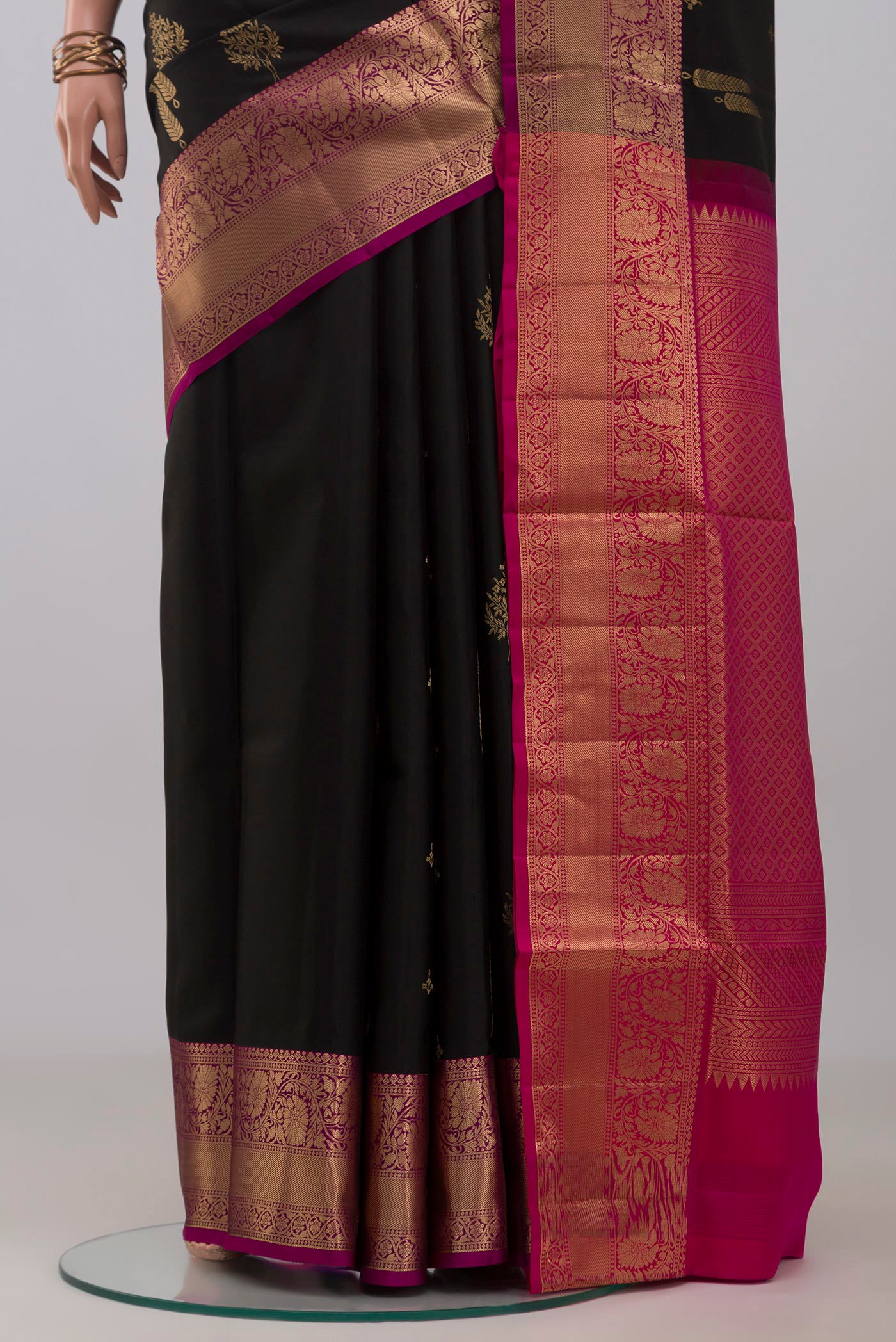 Pleats and pallu of Black Soft Silk Saree with Zari Butta on the body and Zari Border. 