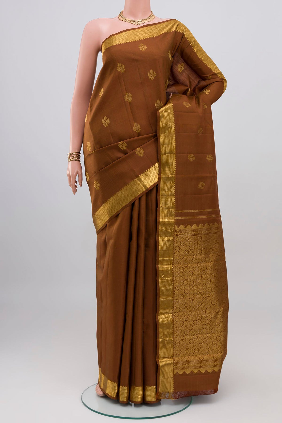 Brown Kanjivaram Silk Saree with Zari Butta on the body and Zari Border.  displayed on a mannequin