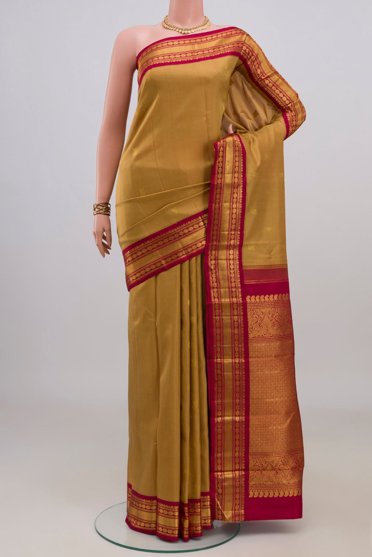 Pure Silk Brown Kanchipuram Saree with Zari Butta on the body and Zari Border.  displayed on a mannequin