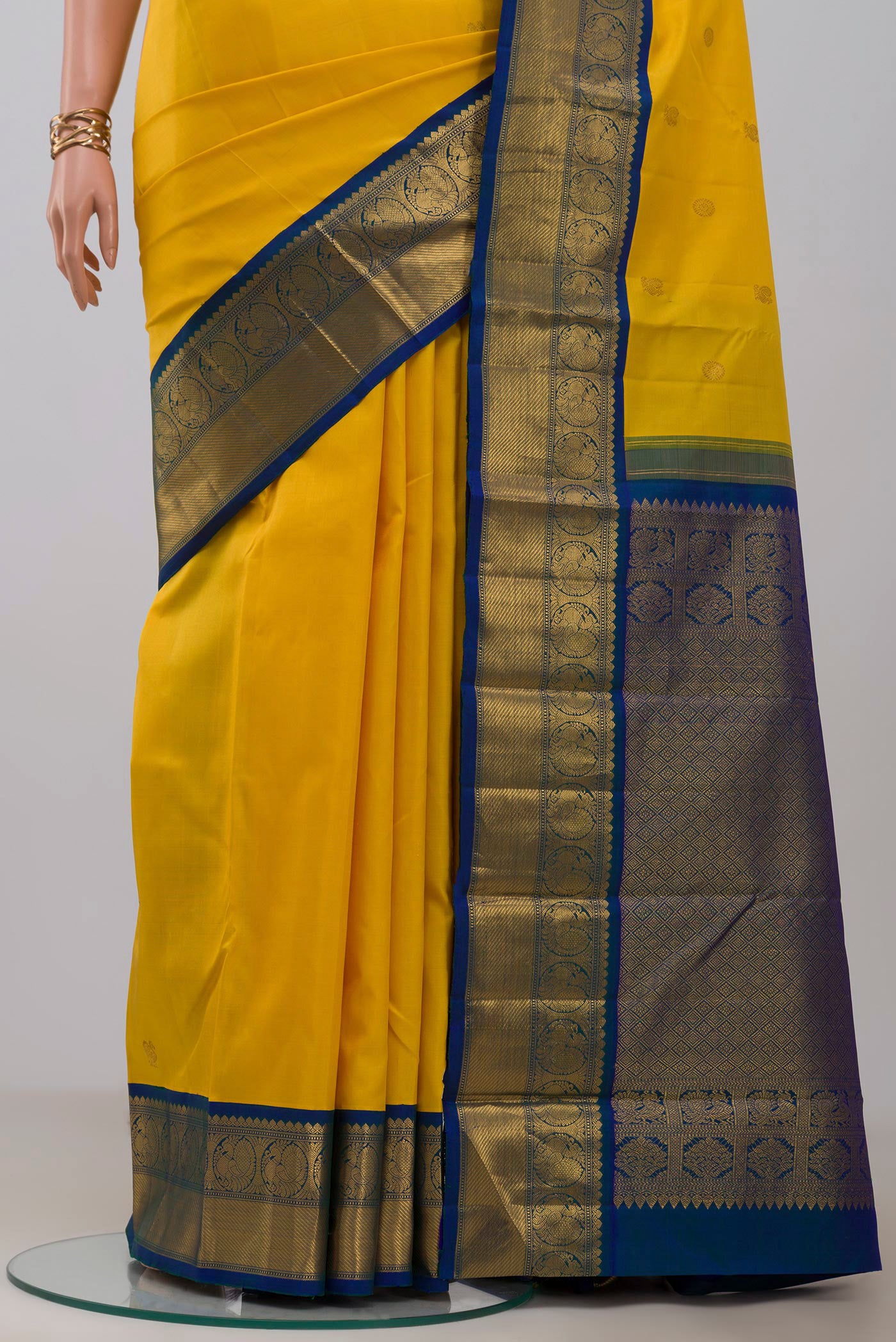 Pleats and pallu of Yellow Kanjivaram Silk Saree with Zari Butta on the body and Zari Border. 