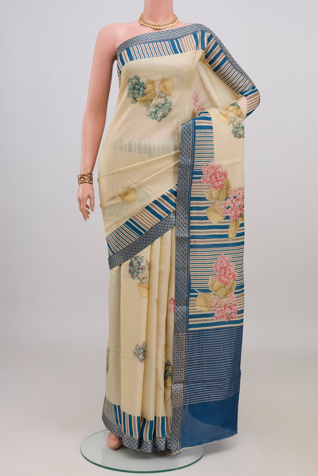 Cream Tussar Silk Saree with Floral Print on the body and Zari Border.  displayed on a mannequin