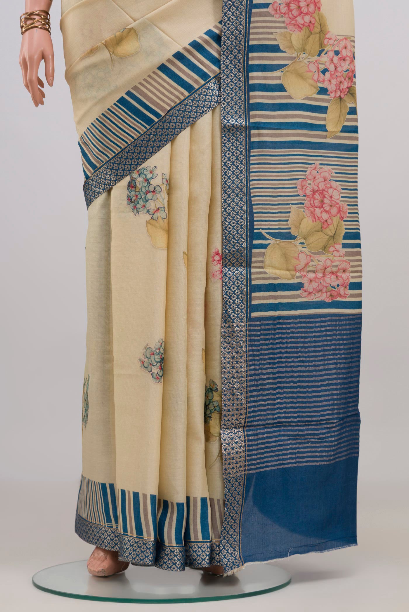 Pleats and pallu of Cream Tussar Silk Saree with Floral Print on the body and Zari Border. 