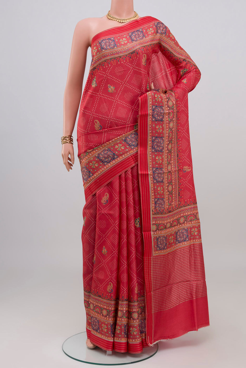 Red Tussar Silk Saree with Printed design on the body and Printed Border.  displayed on a mannequin