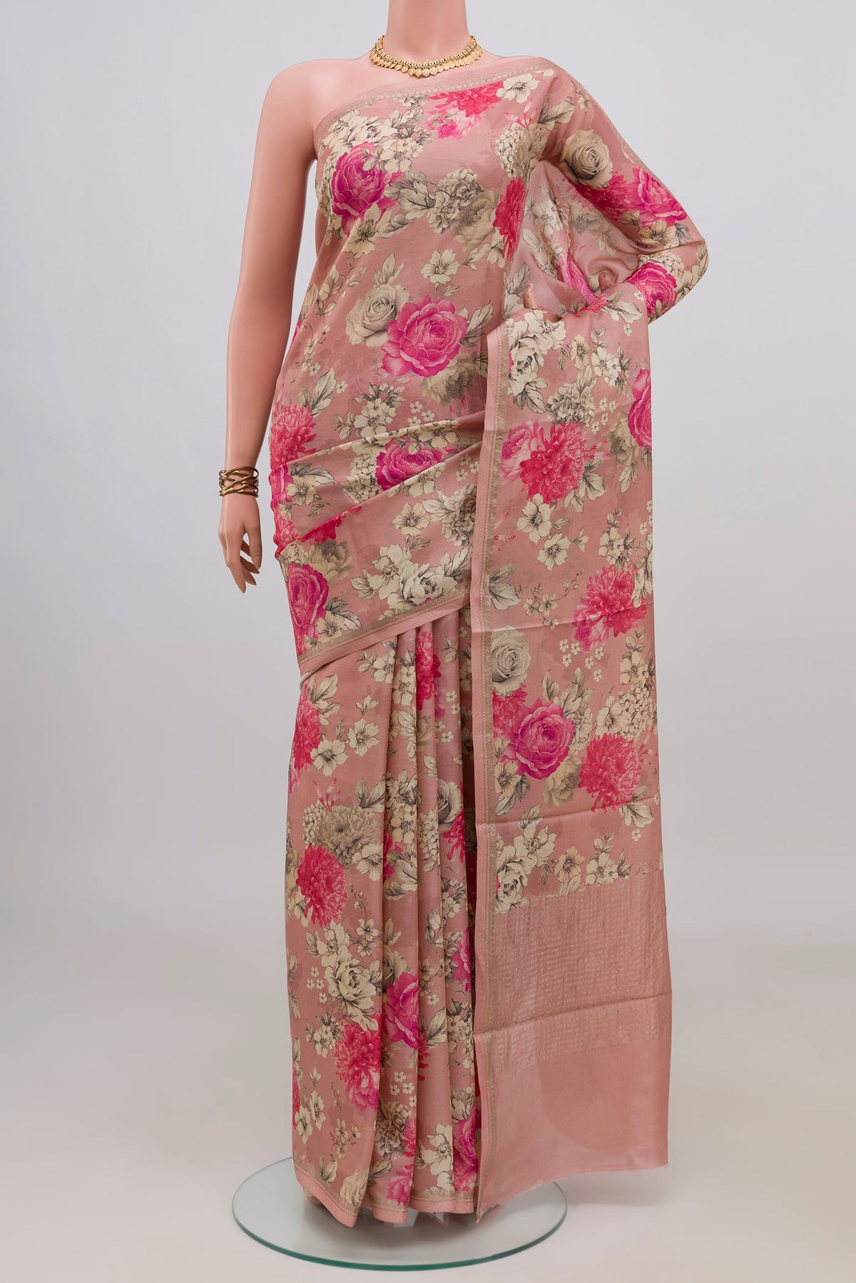 Peach Tussar Saree with Floral Print on the body and Zari Border.  displayed on a mannequin