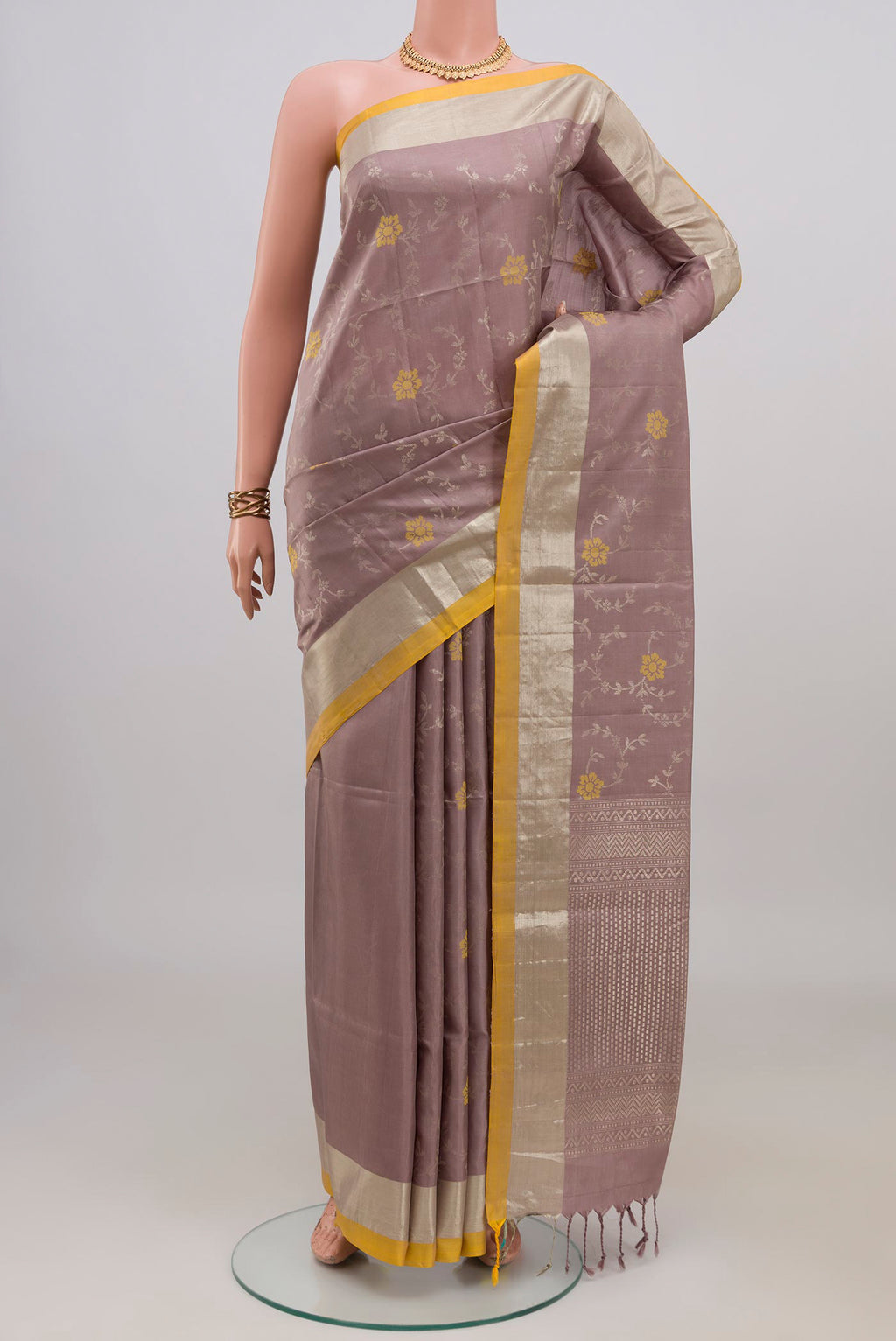 Lavender Soft Silk Saree with Zari Butta on the body and Zari Border.  displayed on a mannequin
