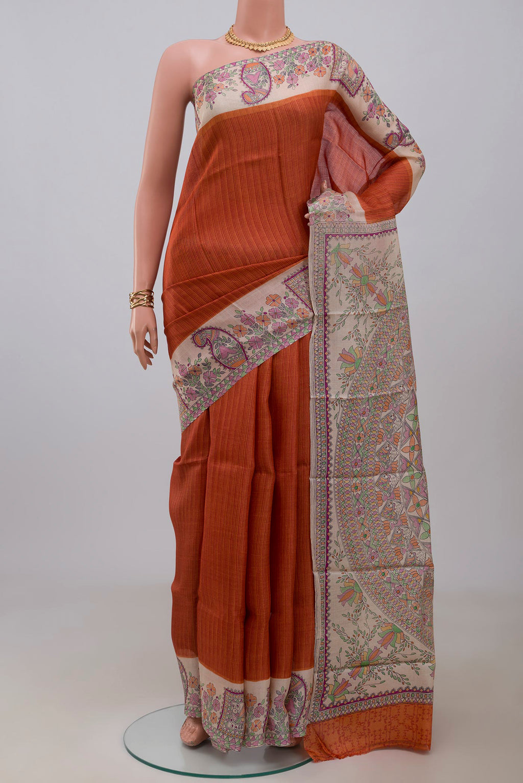 Orange Printed Silk Saree with Printed design on the body and Printed Border.  displayed on a mannequin
