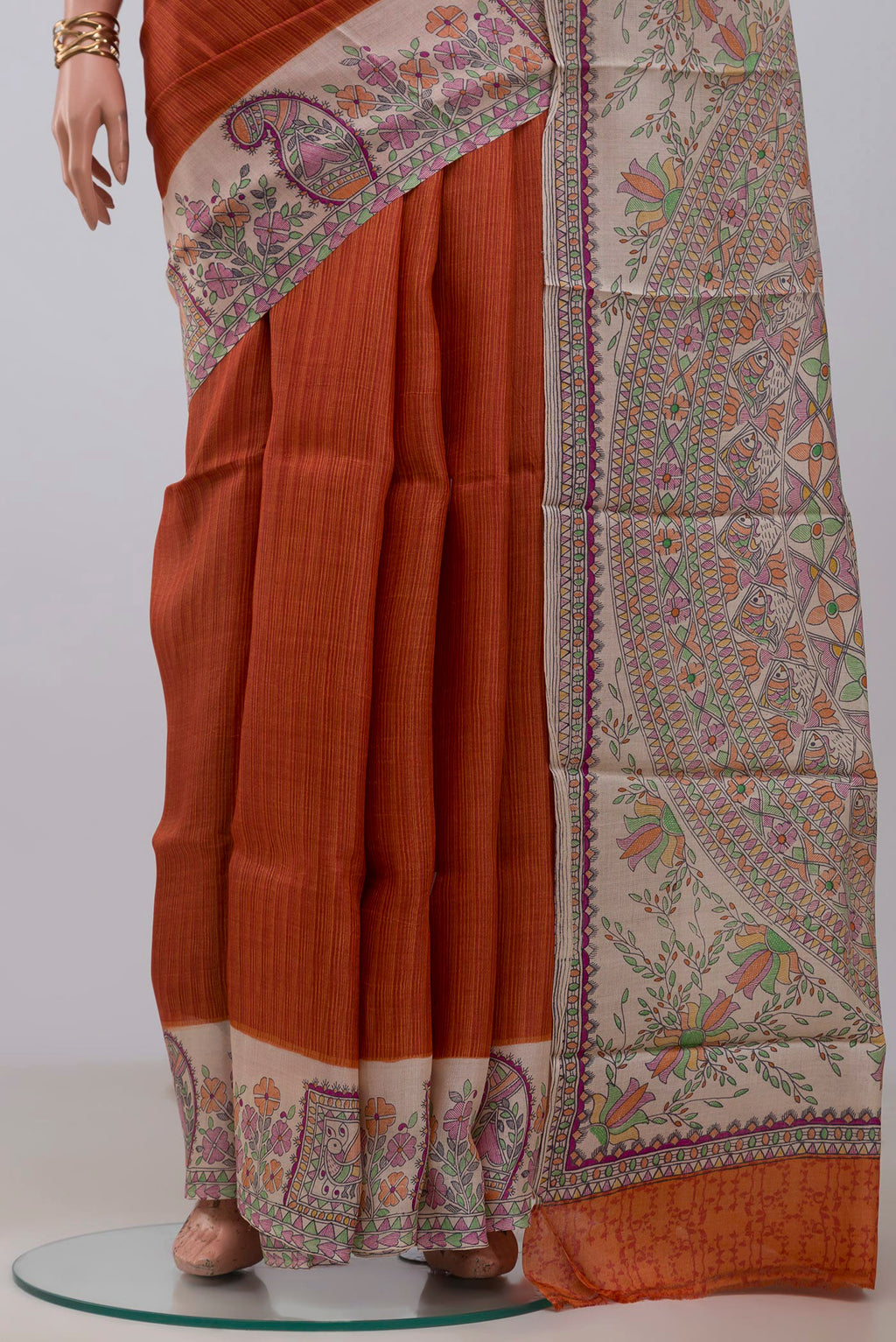 Pleats and pallu of Orange Printed Silk Saree with Printed design on the body and Printed Border. 