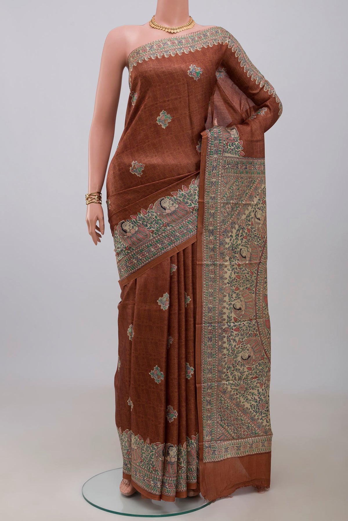 Brown Printed Silk Saree with Printed design on the body and Printed Border.  displayed on a mannequin