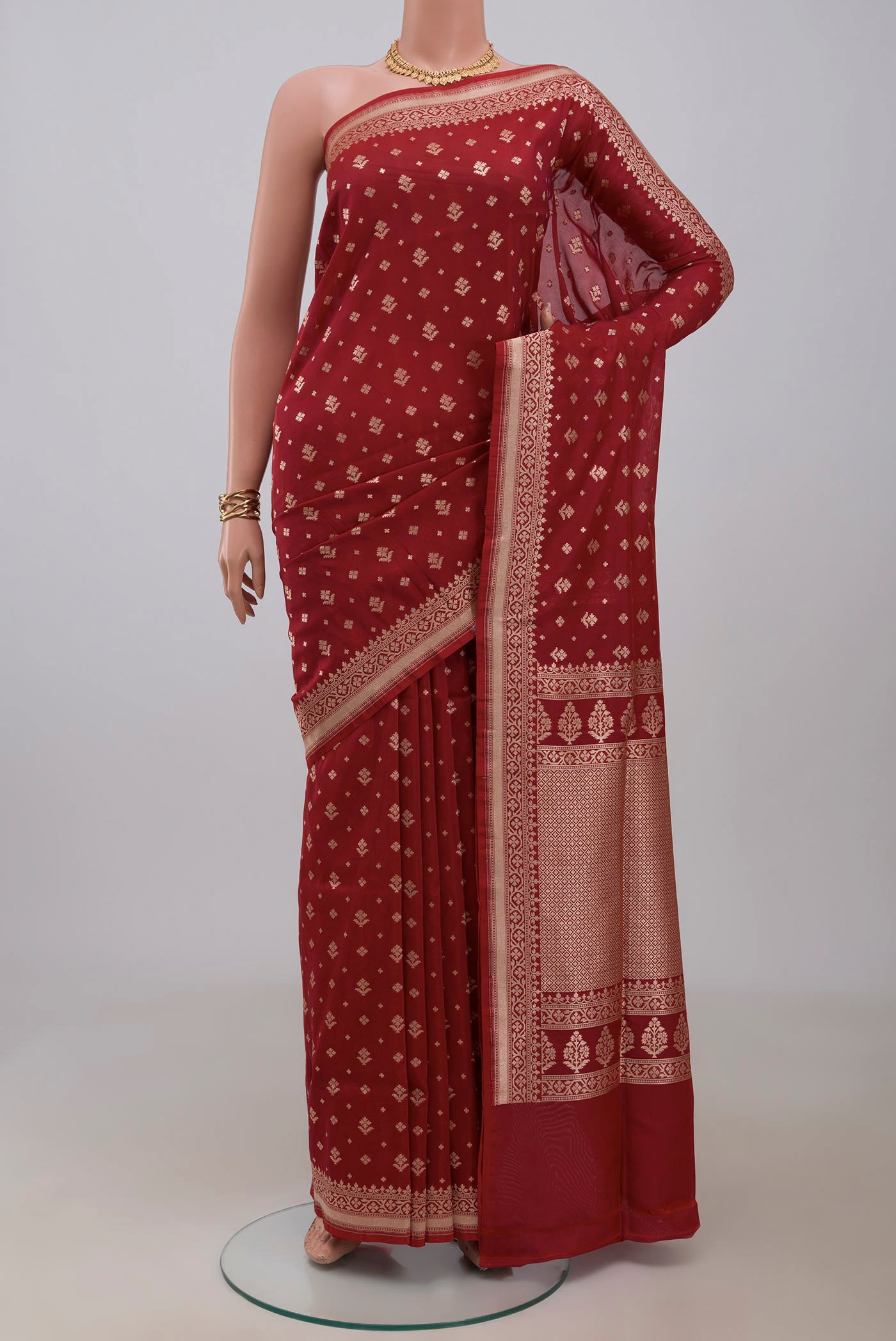 Maroon Banarasi Saree with Zari Butta on the body and Fancy Border.  displayed on a mannequin