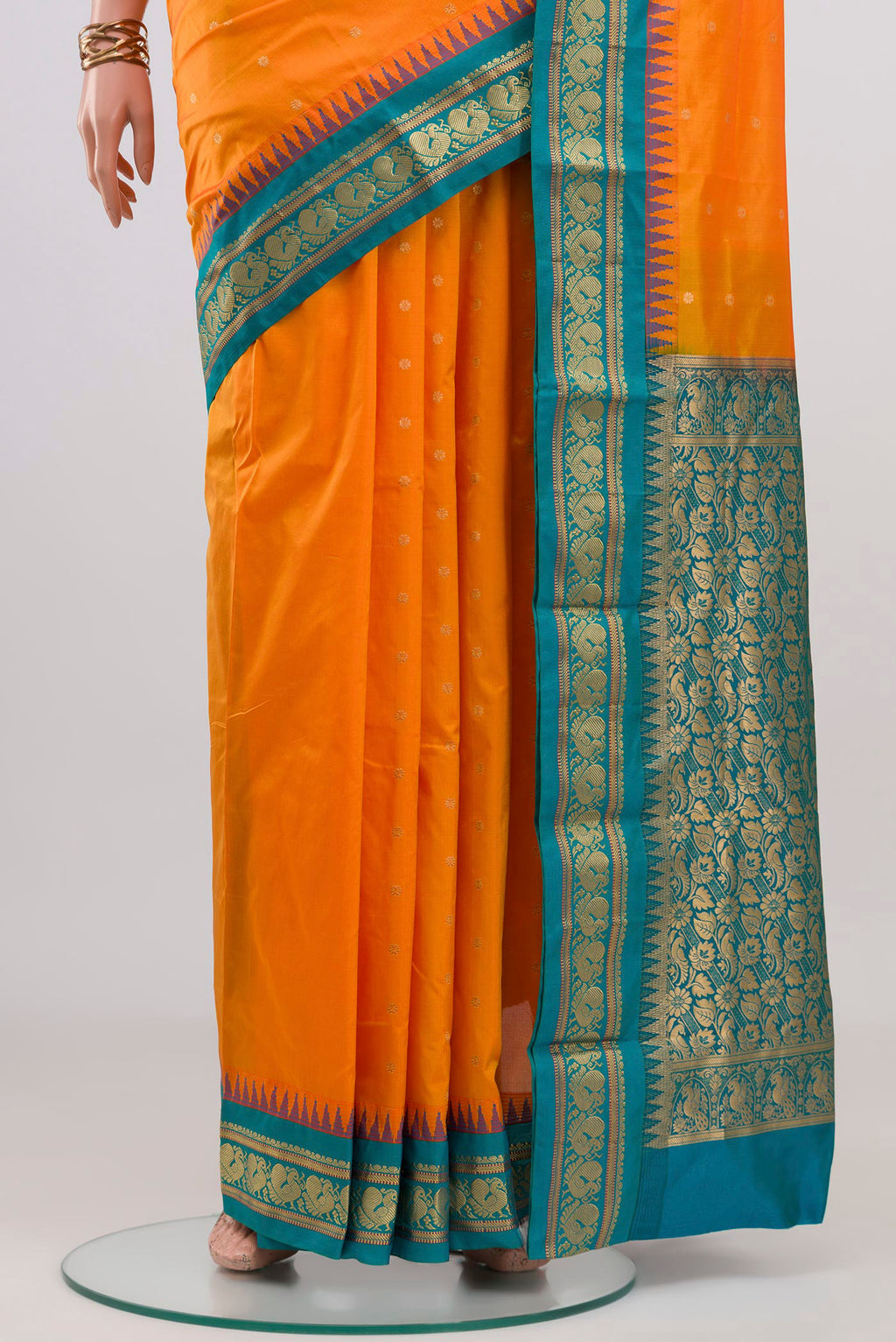 Pleats and pallu of Orange Blended Bangalore Silk Saree with Zari Butta on the body and Zari Border. 