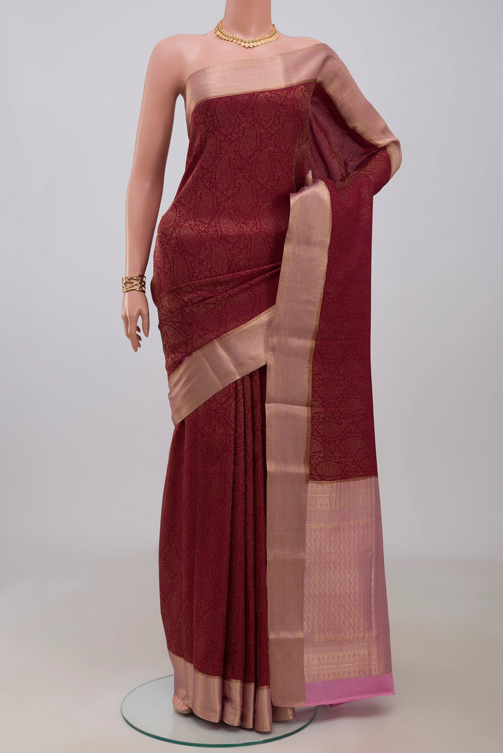Maroon Crepe Saree with Fancy on the body and Zari Border.  displayed on a mannequin