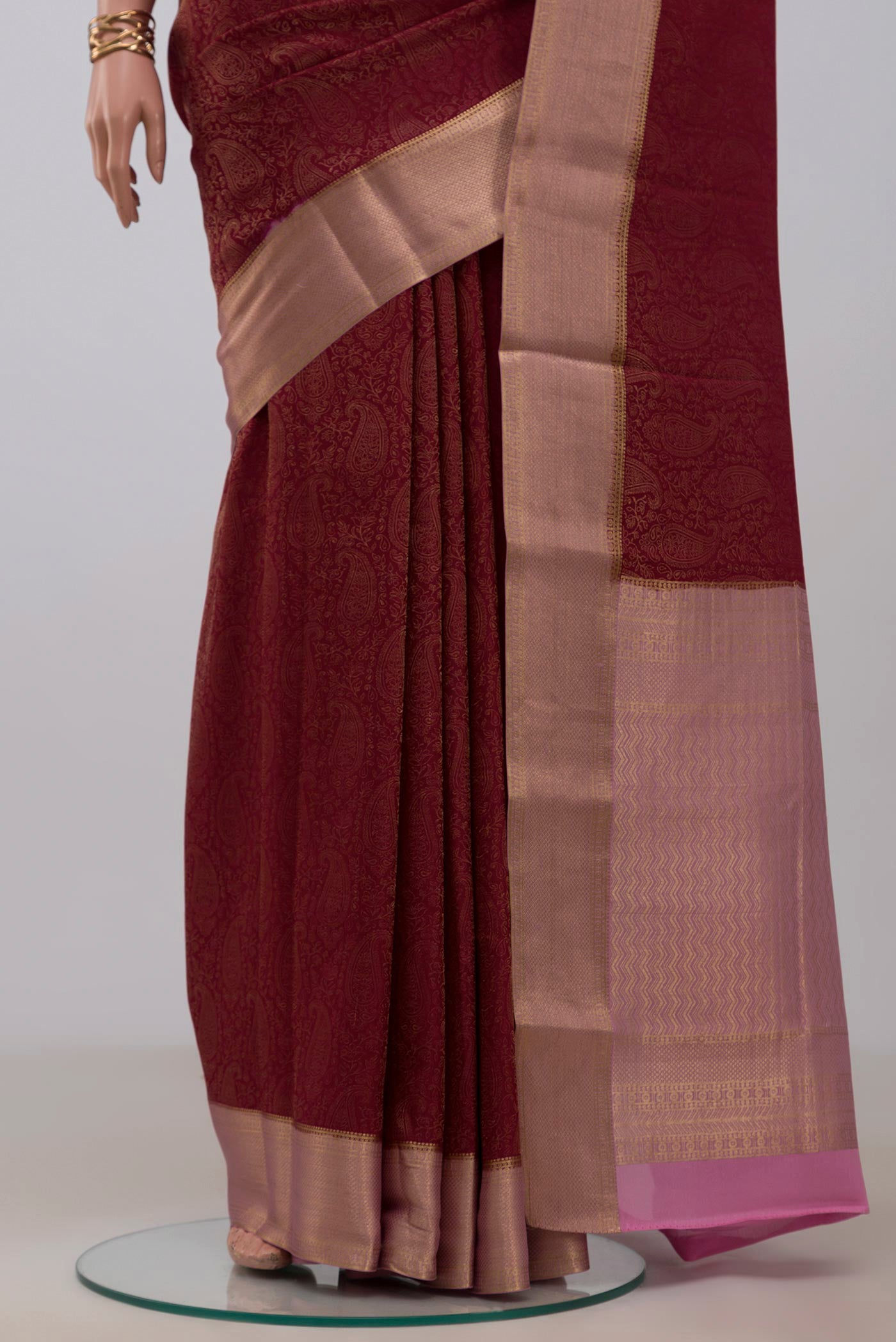 Pleats and pallu of Maroon Crepe Saree with Fancy on the body and Zari Border. 