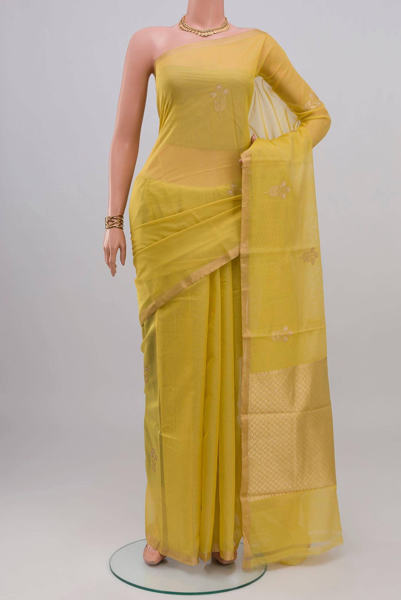 Lemon Yellow Kora Cotton Saree with Zari Butta on the body and Thin Zari Line.  displayed on a mannequin