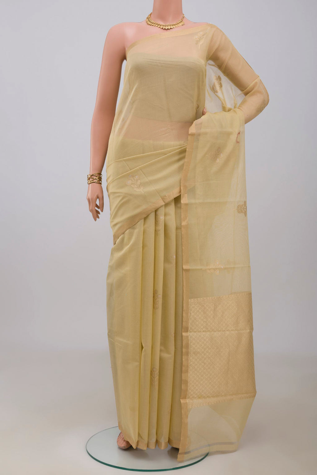 Cream Banarasi Kora Cotton Saree with Zari Butta on the body and Zari Border.  displayed on a mannequin